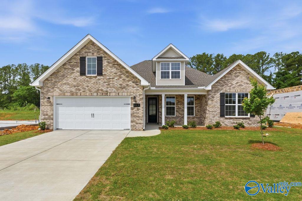 Tan brick 1.5-story Davidson Homes The Rockford with Bonus in Cain Park, Hartselle, Alabama: 2-car garage, front porch, lush lawn