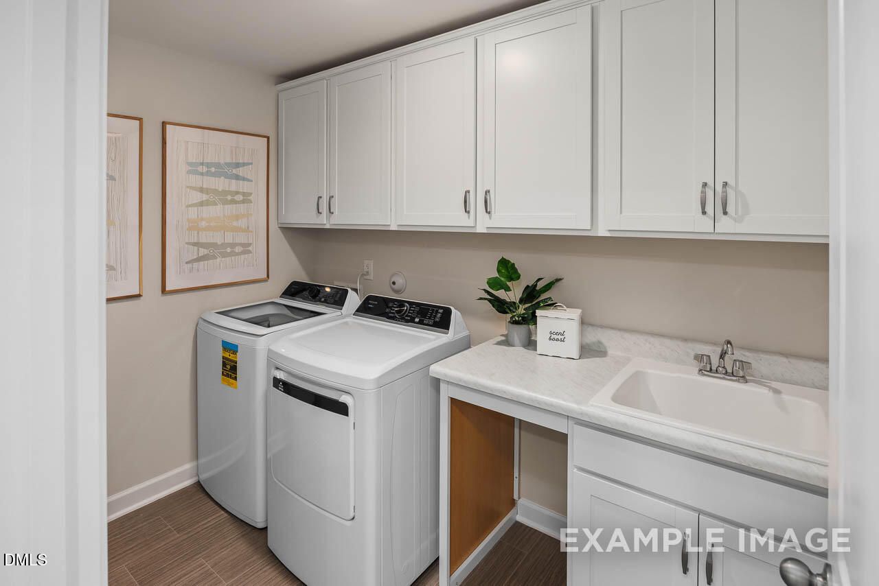 Bright laundry room with white washer, dryer, shaker cabinets, utility sink in Davidson Homes The Willow B, Wake Forest, NC