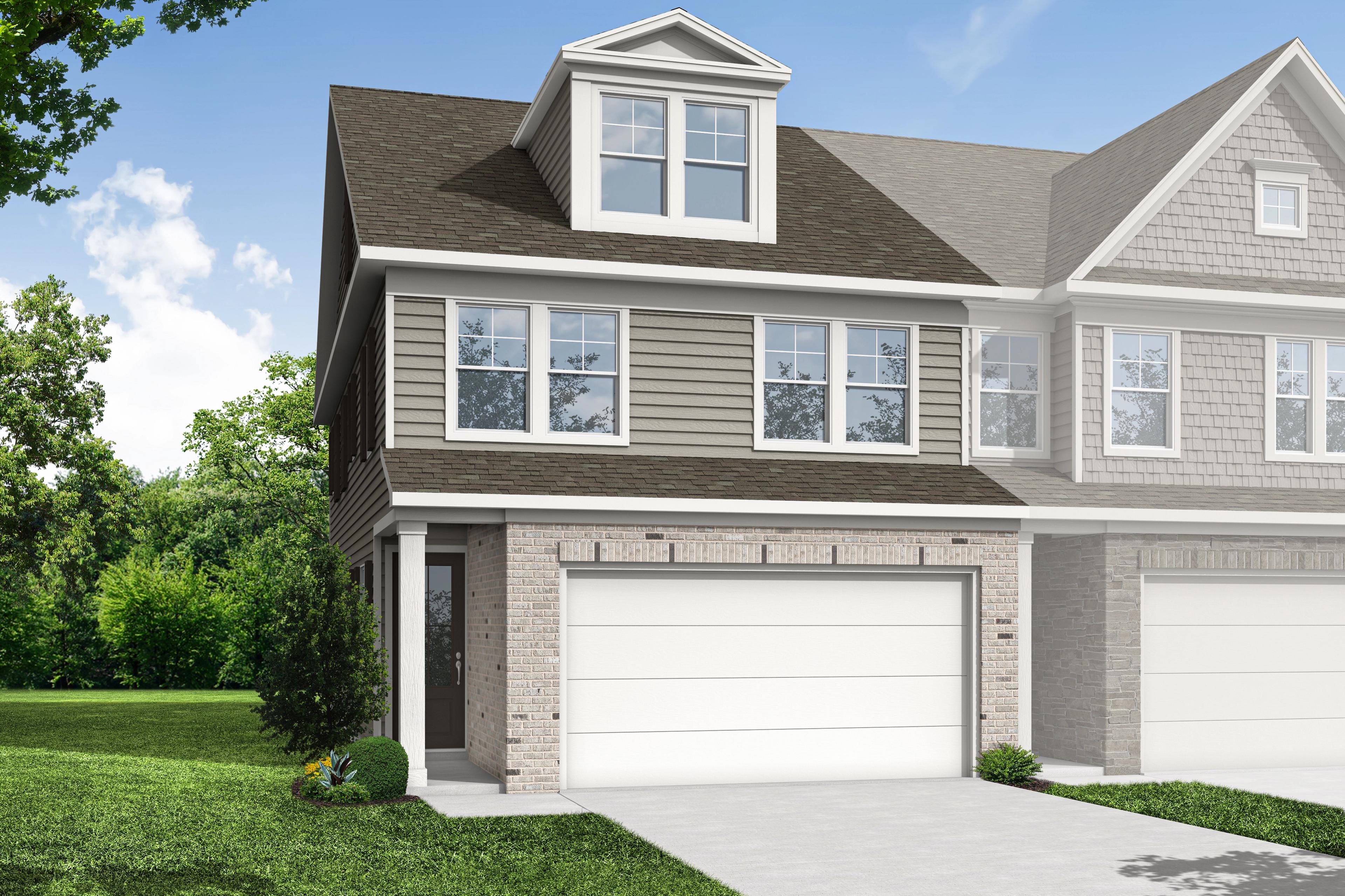 Two-story multi-family duplex exterior of The Wake E with gray siding, brick accents, dormer windows, and attached 2-car garages