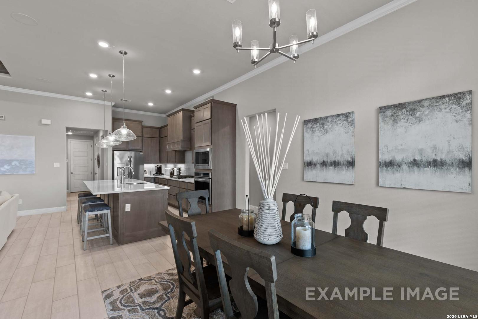 Open-concept kitchen and dining area with modern dark cabinetry in The Garner C plan at The Reserve at Potranco Oaks.