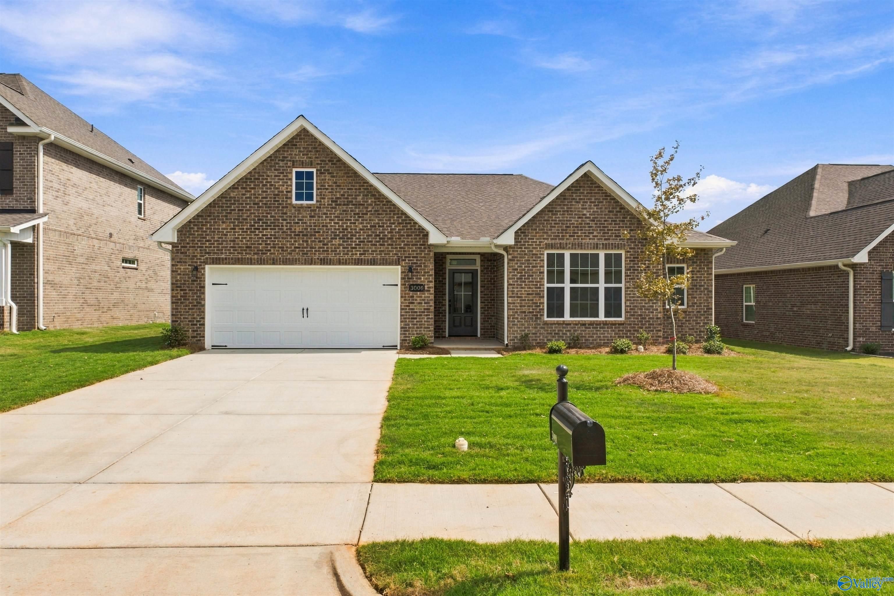 Brick single-story home with 2-car garage and landscaped yard in The Montgomery plan at River Road Estates, Decatur, Alabama