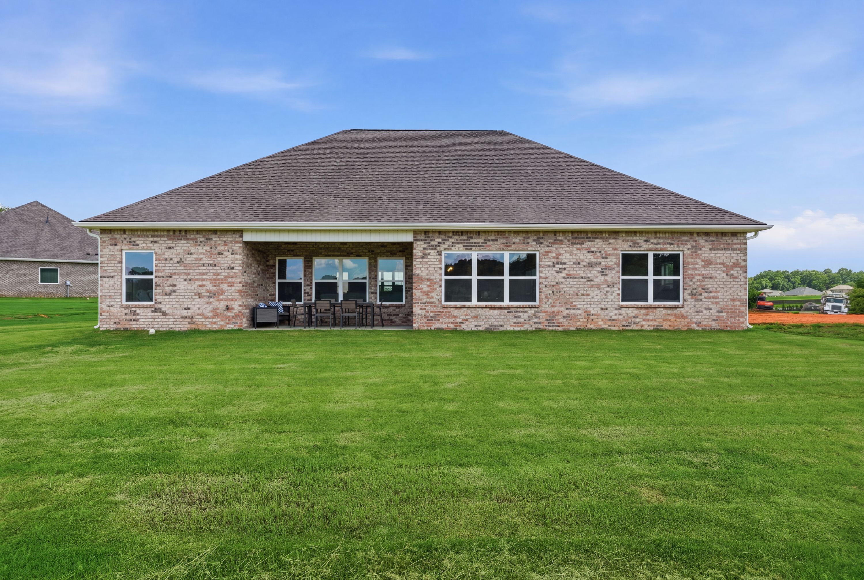 Brick exterior of a Davidson Homes house at Riverton Preserve in Huntsville, AL with a spacious backyard and covered patio.