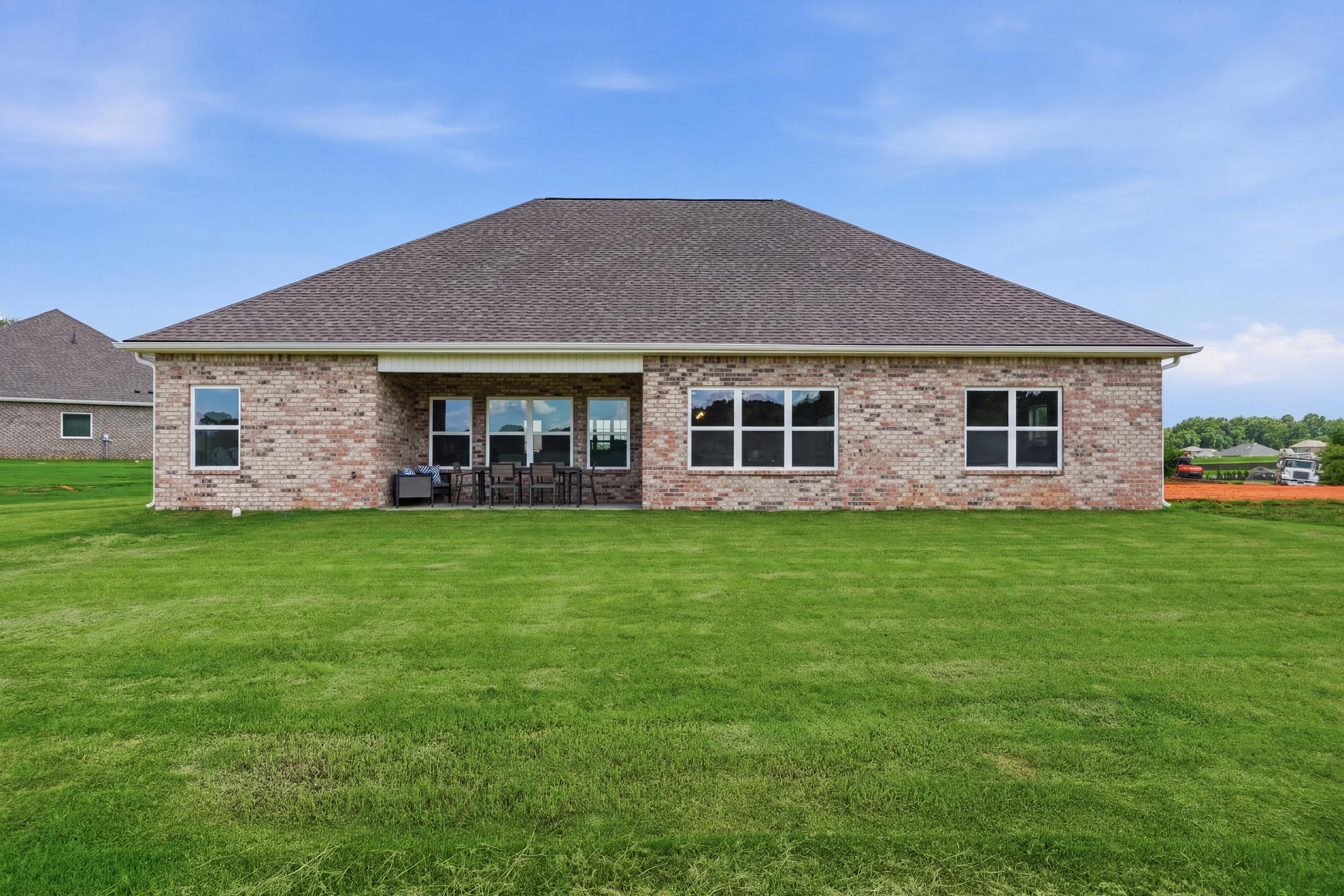 Brick exterior of a Davidson Homes house at Riverton Preserve in Huntsville, AL with a spacious backyard and covered patio.