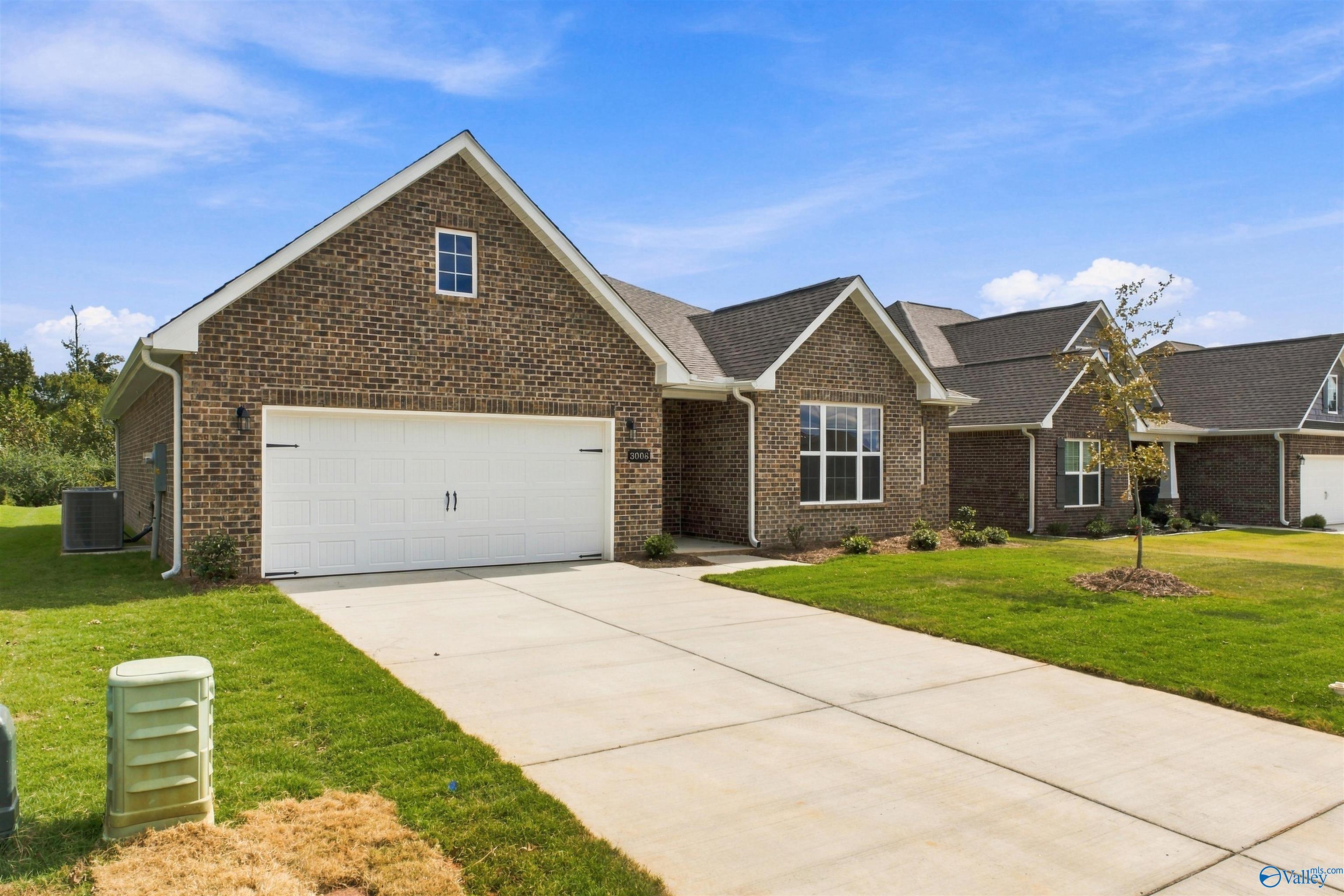 Brick front exterior with 2-car garage and landscaped yard at Davidson Homes' The Montgomery in River Road Estates, Decatur, Alabama