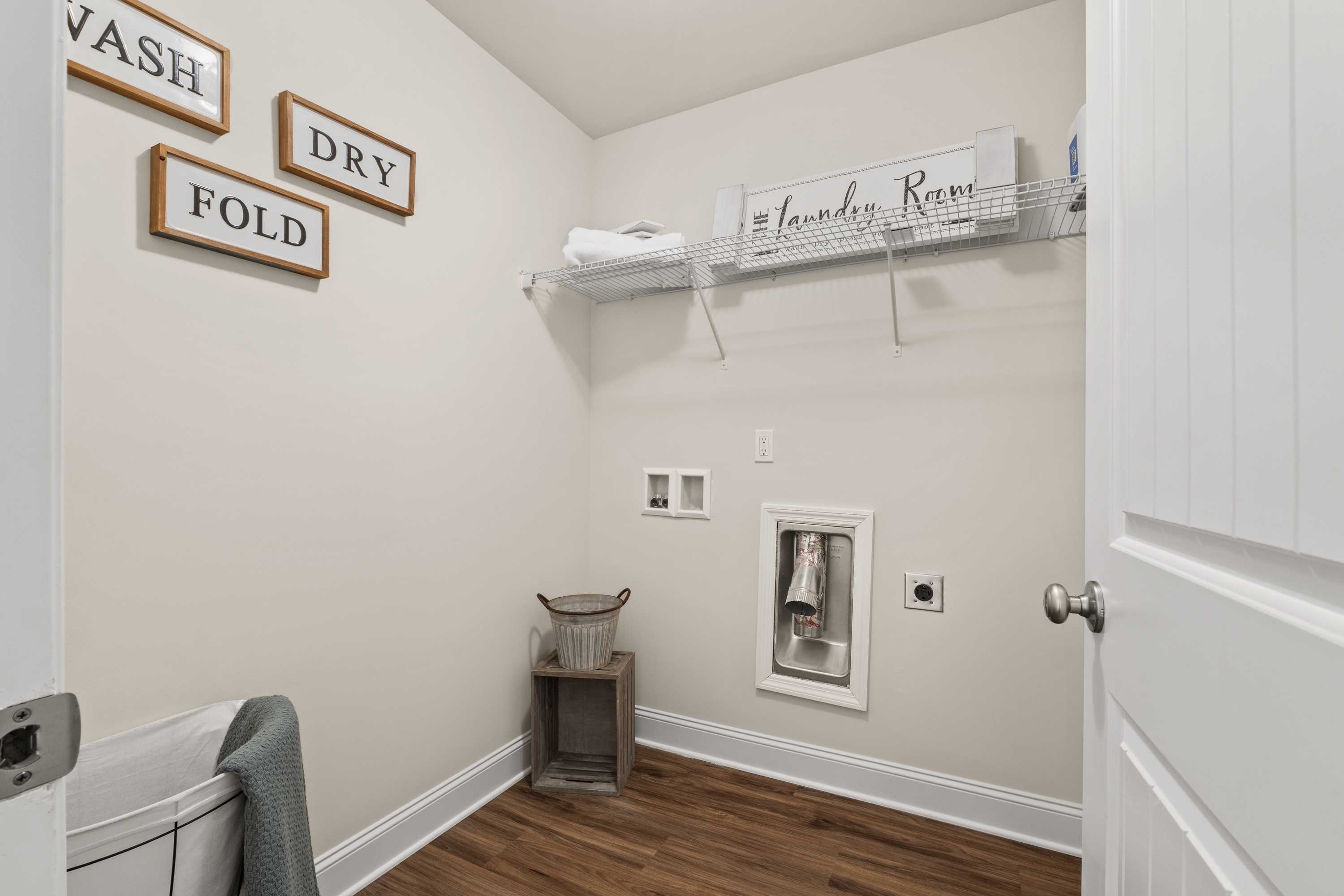 Rustic laundry room in Berry Cove, New Market Alabama with wooden wash dry fold signs, open shelving, and hardwood floors