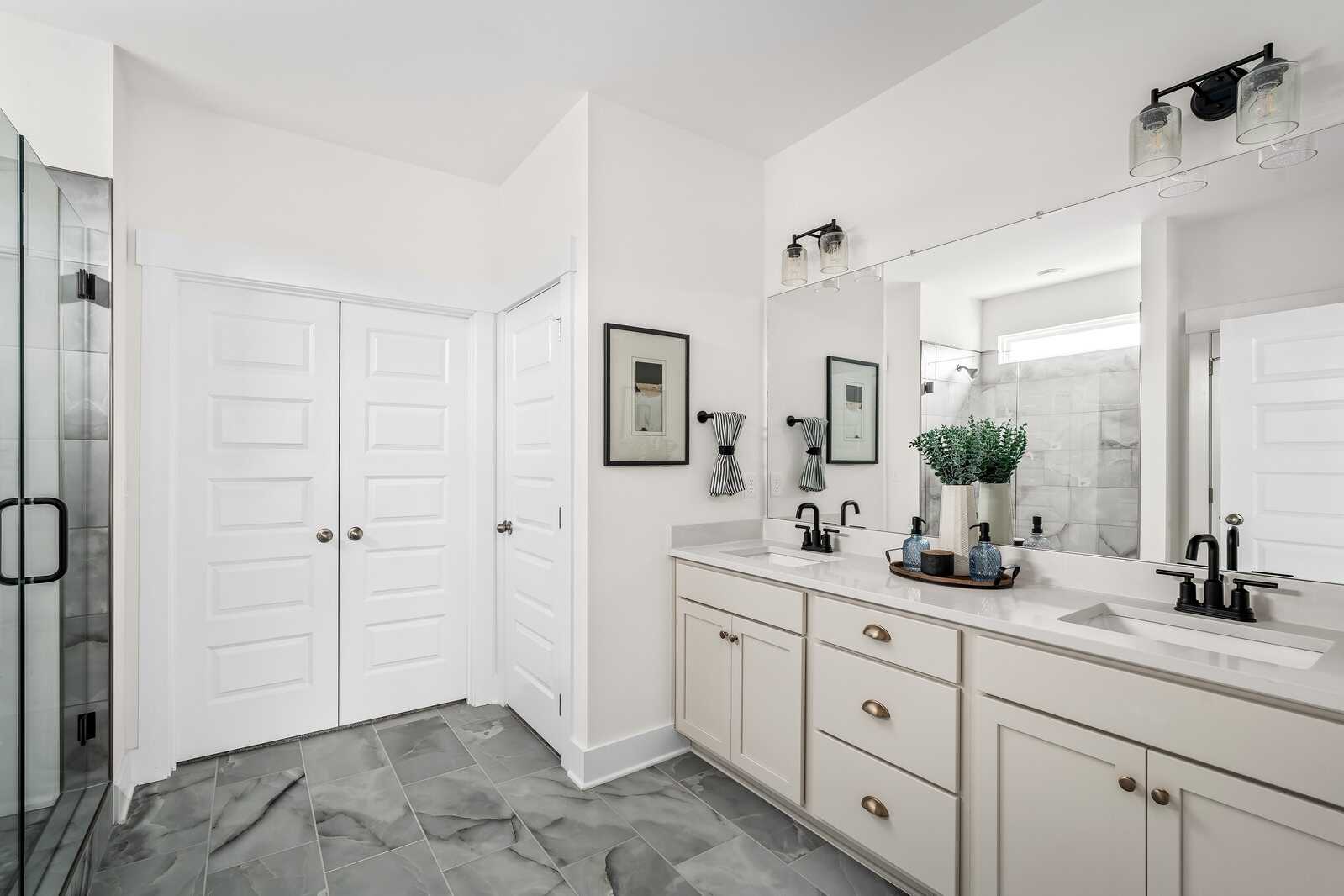 Luxury primary bathroom at Woods Crossing in Gallatin TN with double vanity, glass shower, and shaker cabinets