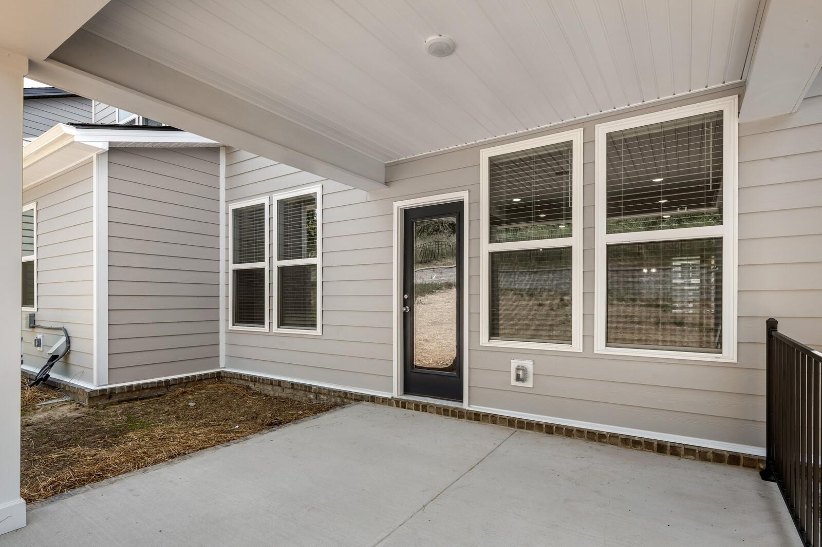Covered concrete patio with glass door and siding exterior of The Willow floor plan in Woods Crossing, Gallatin, Tennessee.