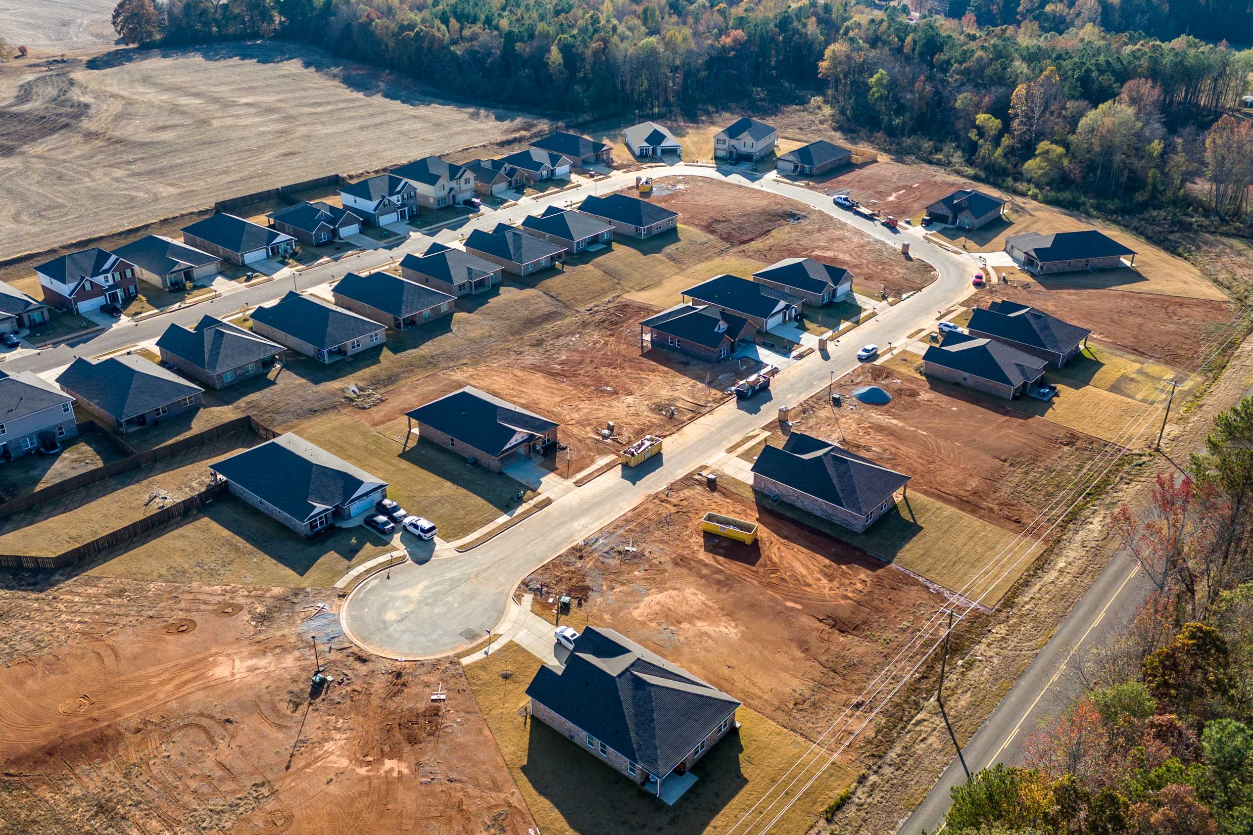 Aerial view of new homes under construction at Mallard Landing in Athens Alabama with curved streets and wooded surroundings