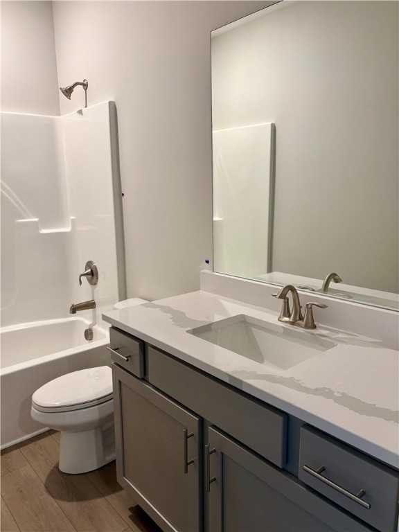Modern bathroom with white tub, shower, gray vanity, quartz countertop in Davidson Homes The Luna B, Opelika, Alabama