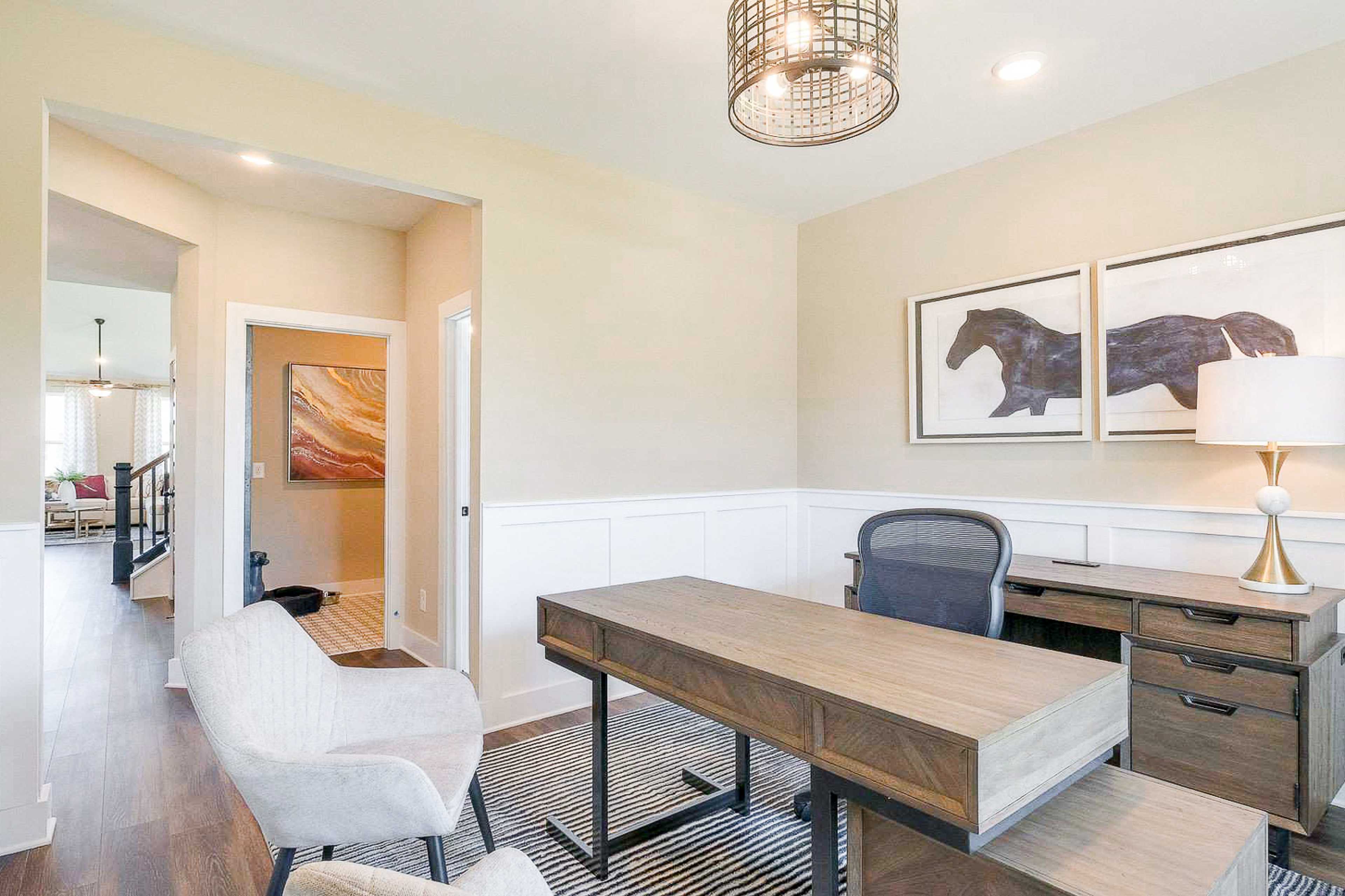 Bright home office in The Meadows Smyrna TN with wooden desk, ergonomic chair, wainscoted walls, and horse artwork