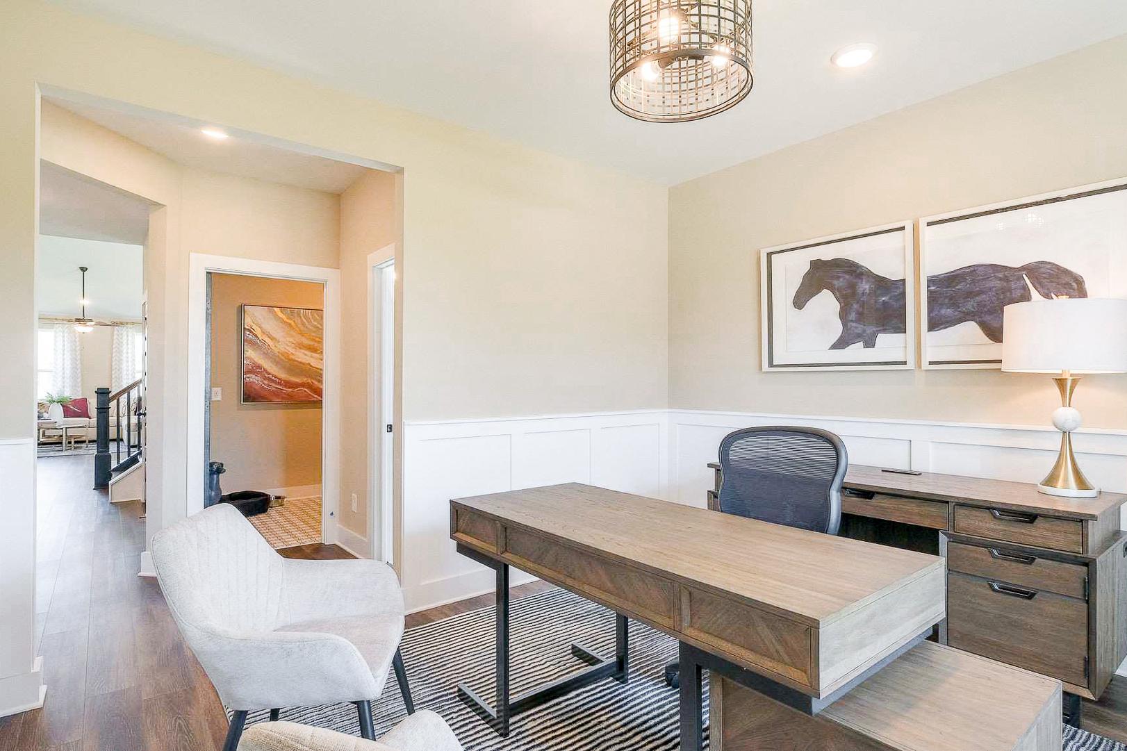 Bright home office in The Meadows Smyrna TN with wooden desk, ergonomic chair, wainscoted walls, and horse artwork
