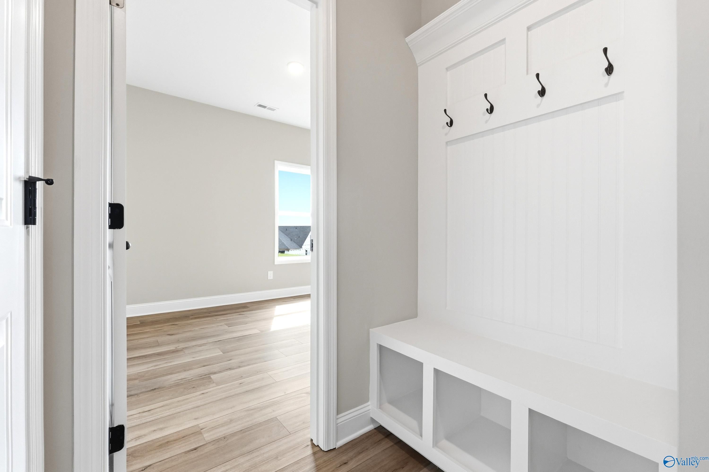Built-in mudroom bench with coat hooks in the Daphne D floor plan by Davidson Homes in Creekside, Harvest, Alabama.
