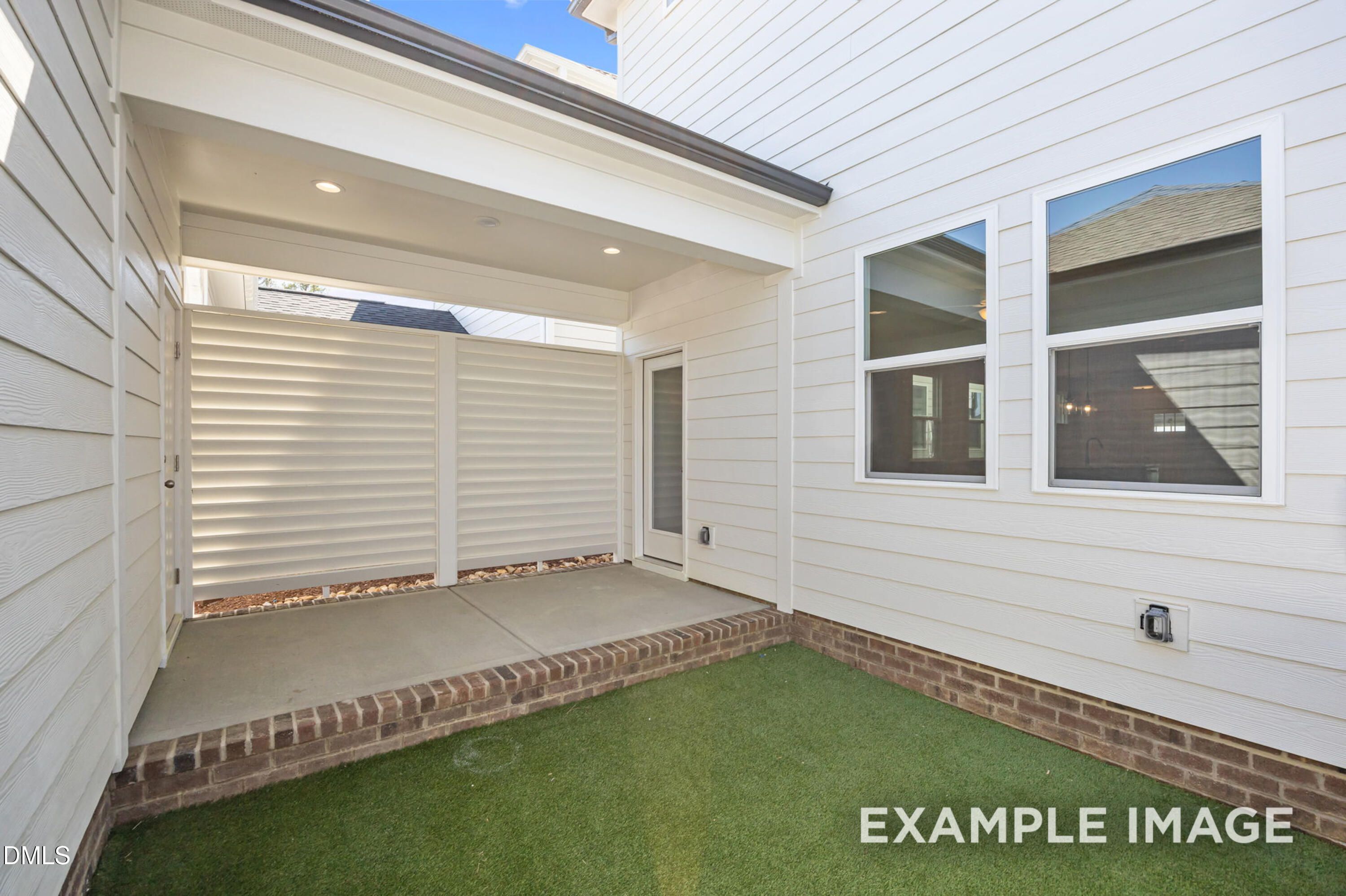 Private covered patio with brick trim and privacy screen at The Alexander B home in Forestville Yard, Knightdale, NC.