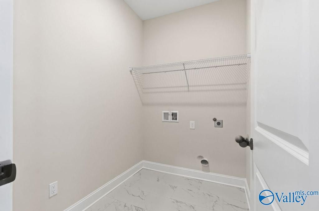 Spacious laundry room with wire shelving, washer-dryer hookups, and tile flooring in Davidson Homes The Montgomery B, Hartselle, AL