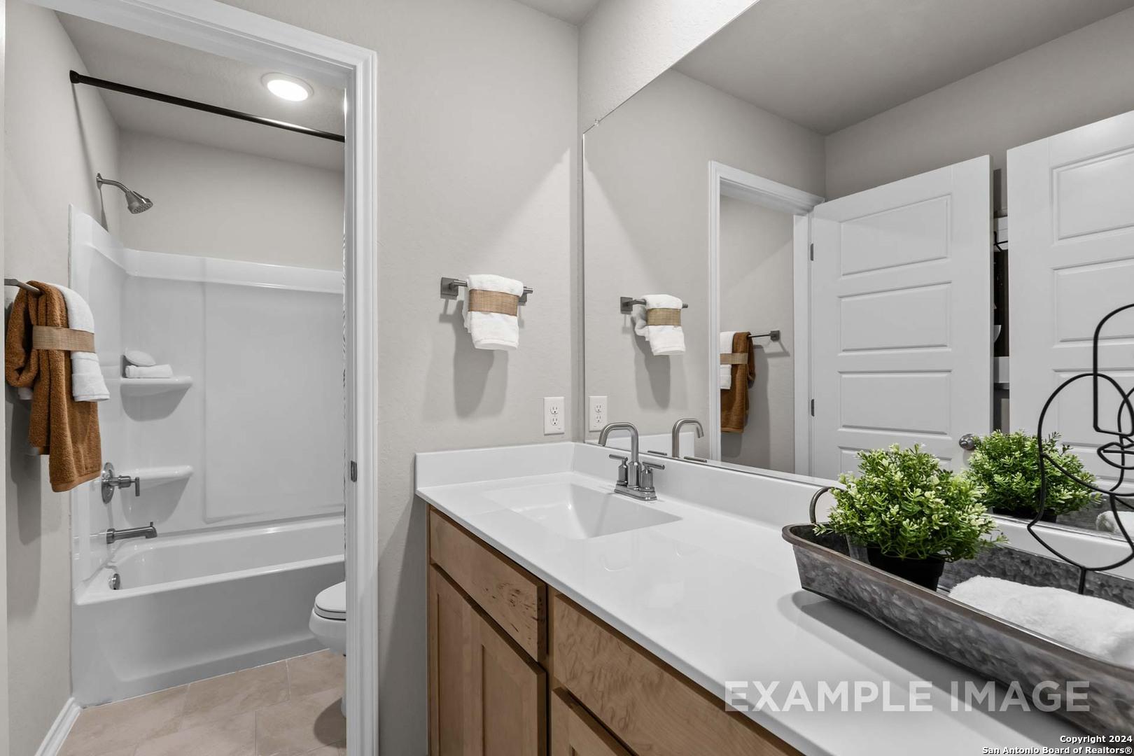 Elegant master bathroom with soaking tub, glass shower, double-sink vanity in The Sabine B by Davidson Homes, San Antonio