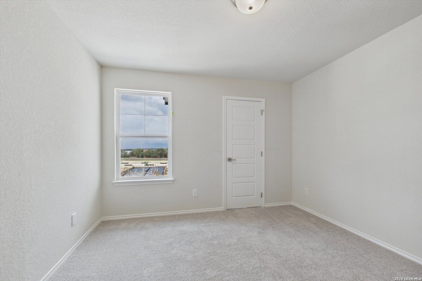 Bright, neutral-toned bedroom in The Charlotte B floor plan by Davidson Homes at Meadows at Oak Creek, San Antonio.