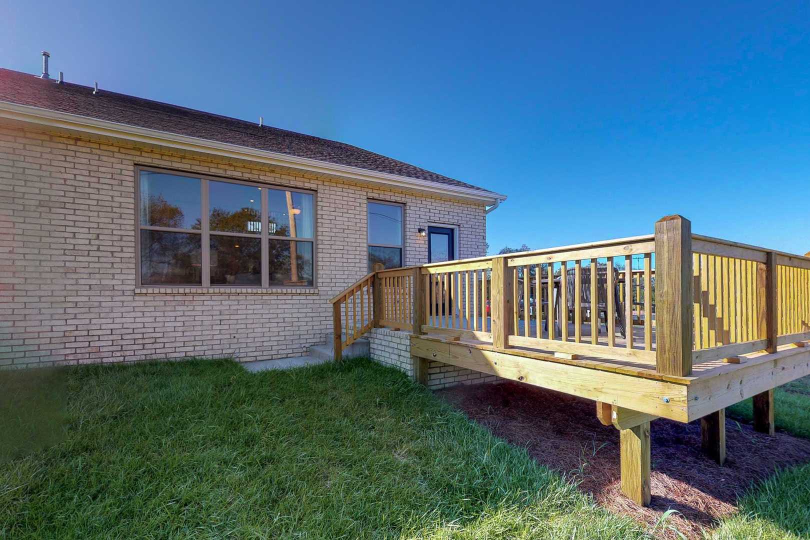 Brick home backyard deck with wooden railings and stairs at Liberty Creek in Gallatin, Tennessee by Davidson Homes