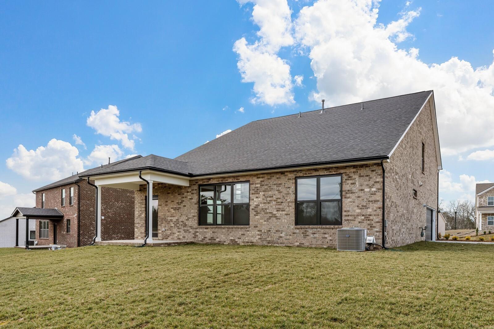Rear view of 2-story brick home with covered patio, The Ridgeport D floor plan by Davidson Homes in Mt. Juliet, Tennessee.