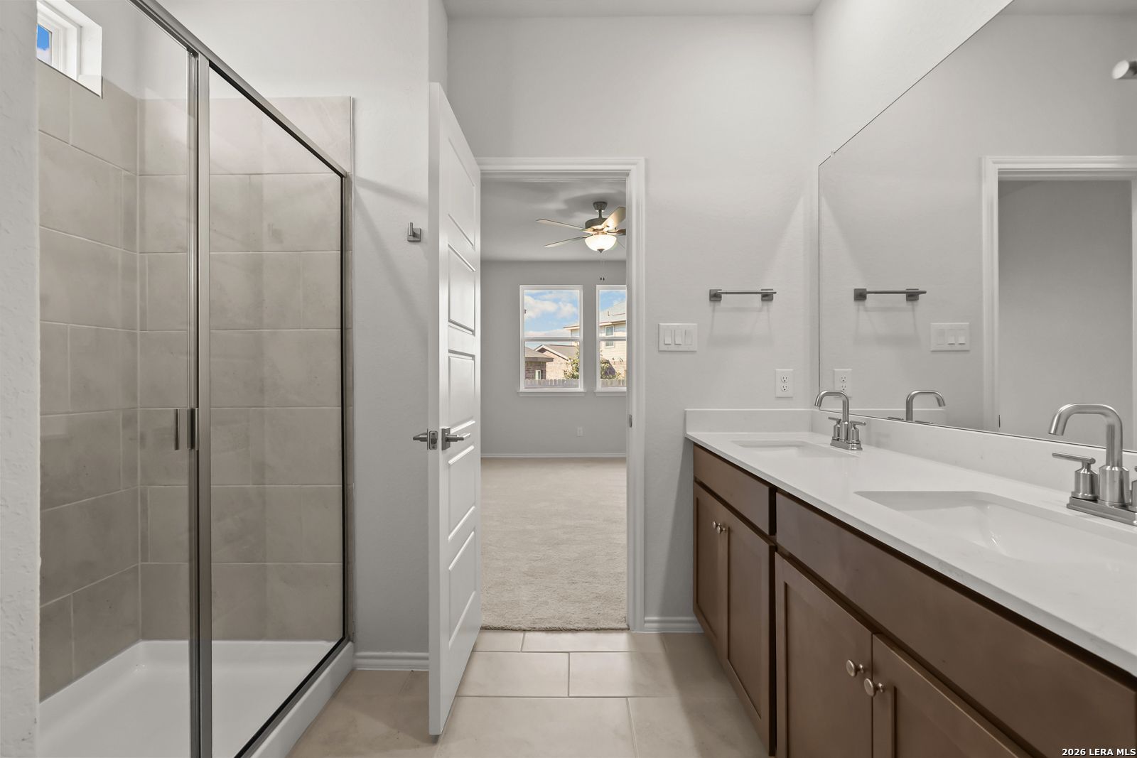Modern master bathroom with glass walk-in shower, dual vanity, and large mirror in Davidson Homes The Daphne I, Bricewood, San Antonio, TX