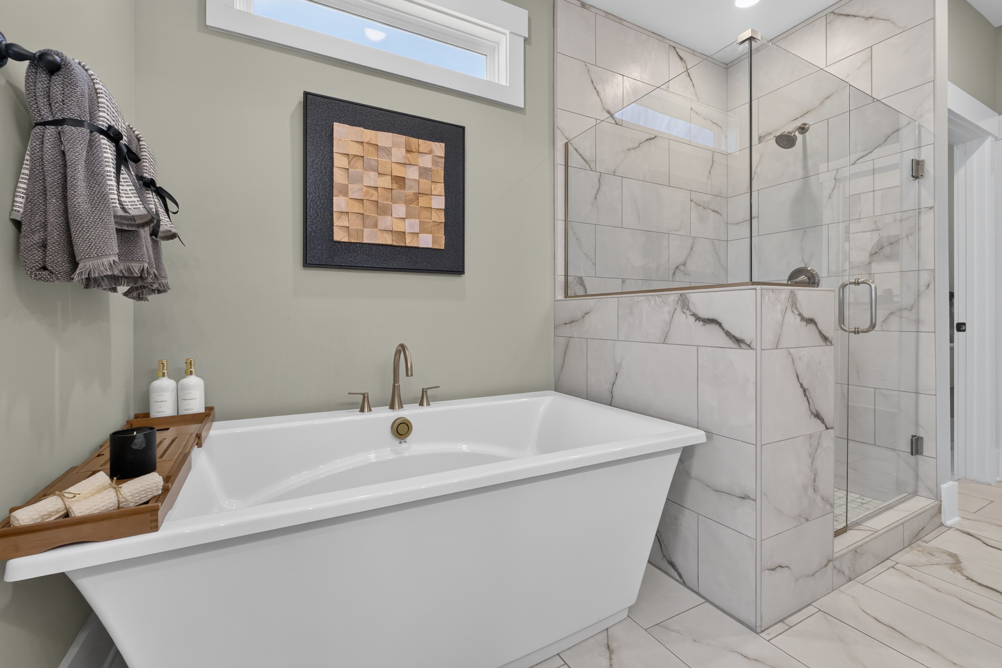 Spa-inspired master bathroom at Evergreen Mill in Madison, AL with freestanding tub, marble tile walk-in shower by Davidson Homes