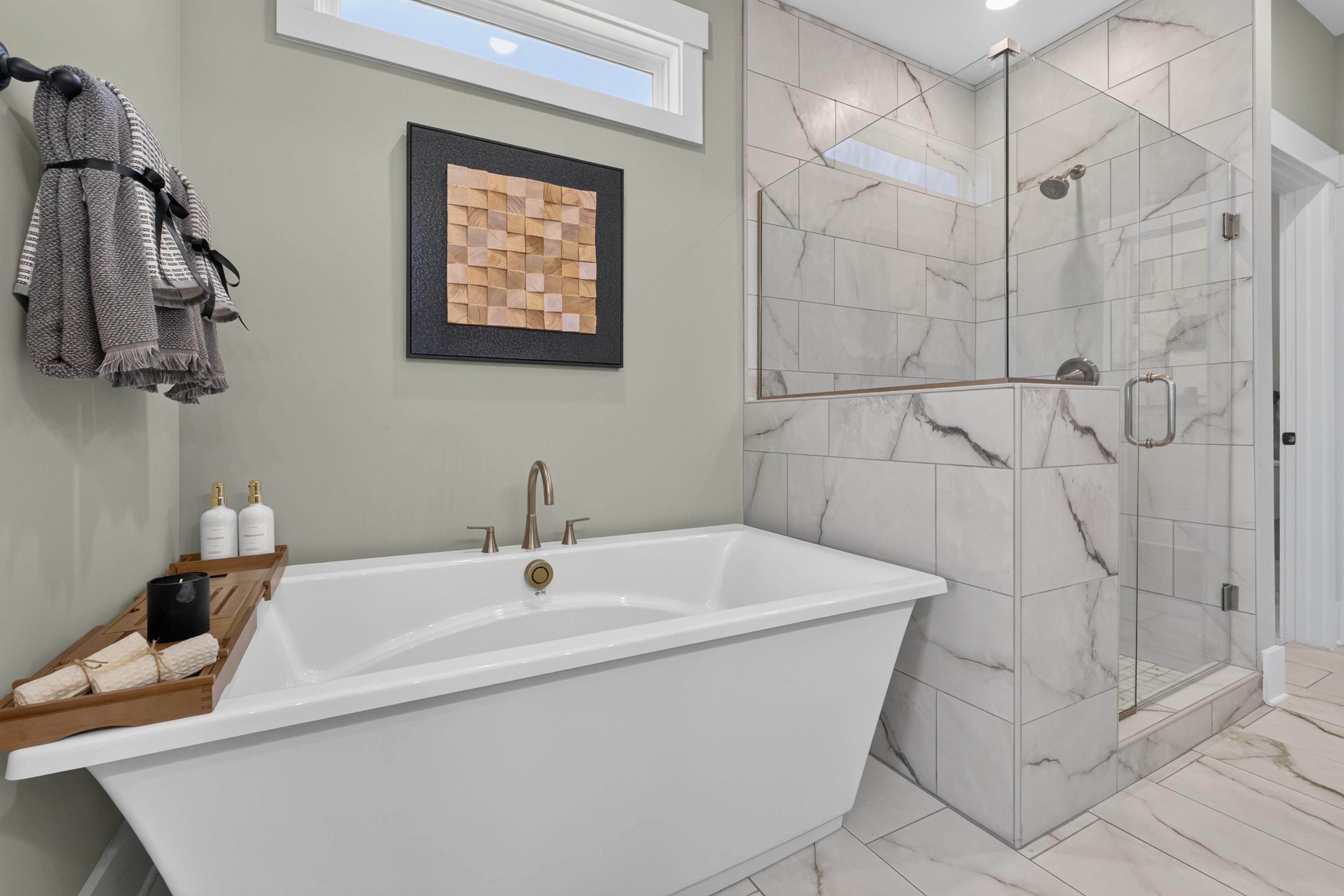 Spa-inspired master bathroom at Evergreen Mill in Madison, AL with freestanding tub, marble tile walk-in shower by Davidson Homes