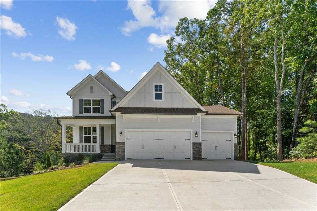 Modern craftsman-style single-story home with 3-car garage, front porch, and tree-lined driveway in Riverwood, Dallas, Georgia