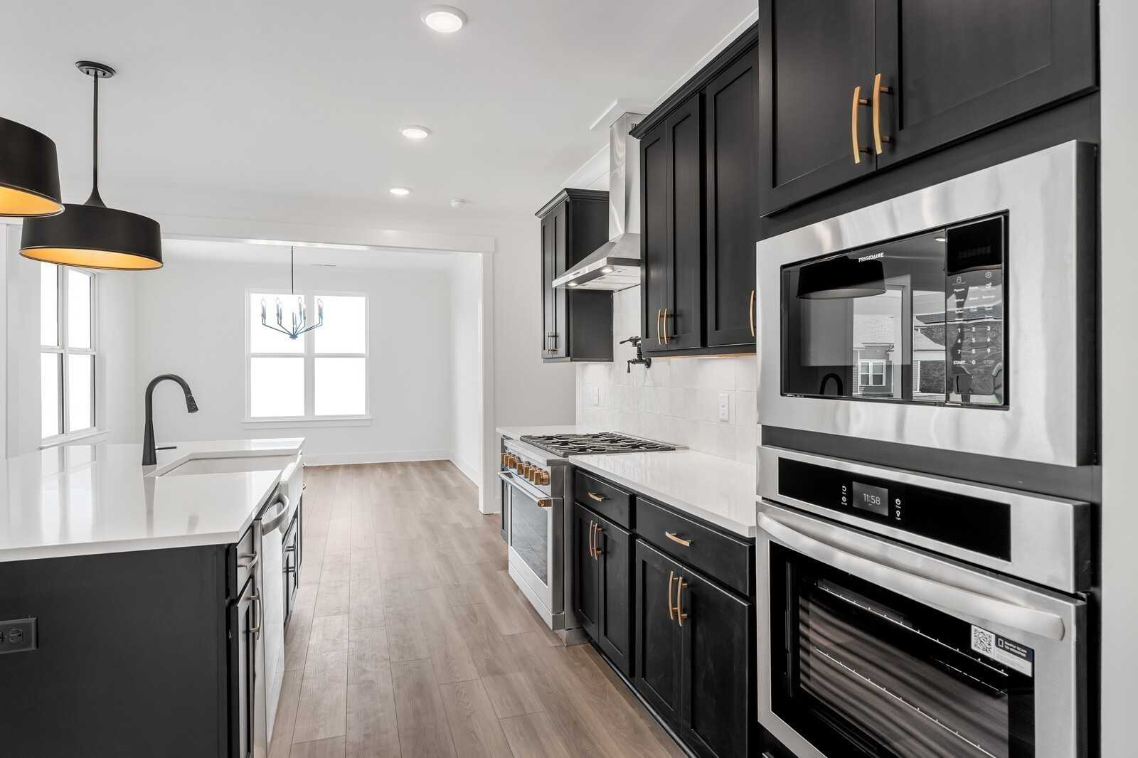 Modern kitchen featuring black shaker cabinets, white quartz island, stainless steel appliances in Davidson Homes The Hathaway, Murfreesboro TN
