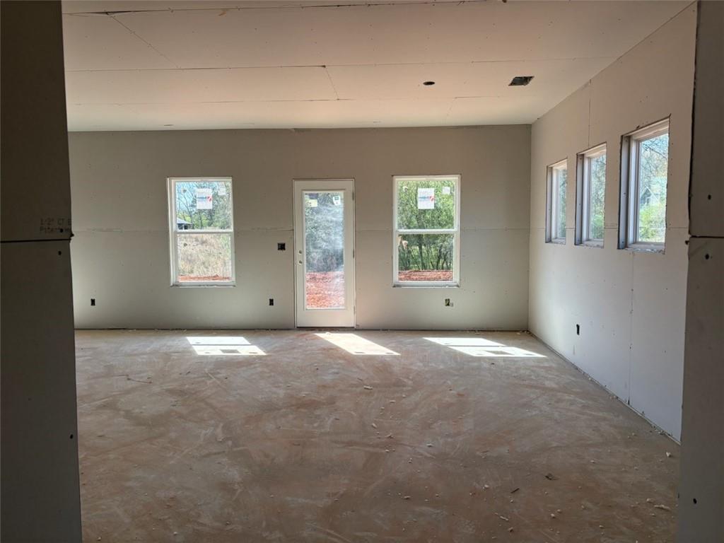 Bright unfinished bonus room with large windows, sliding door, and natural light in Davidson Homes The Rabun A, Winder, Georgia