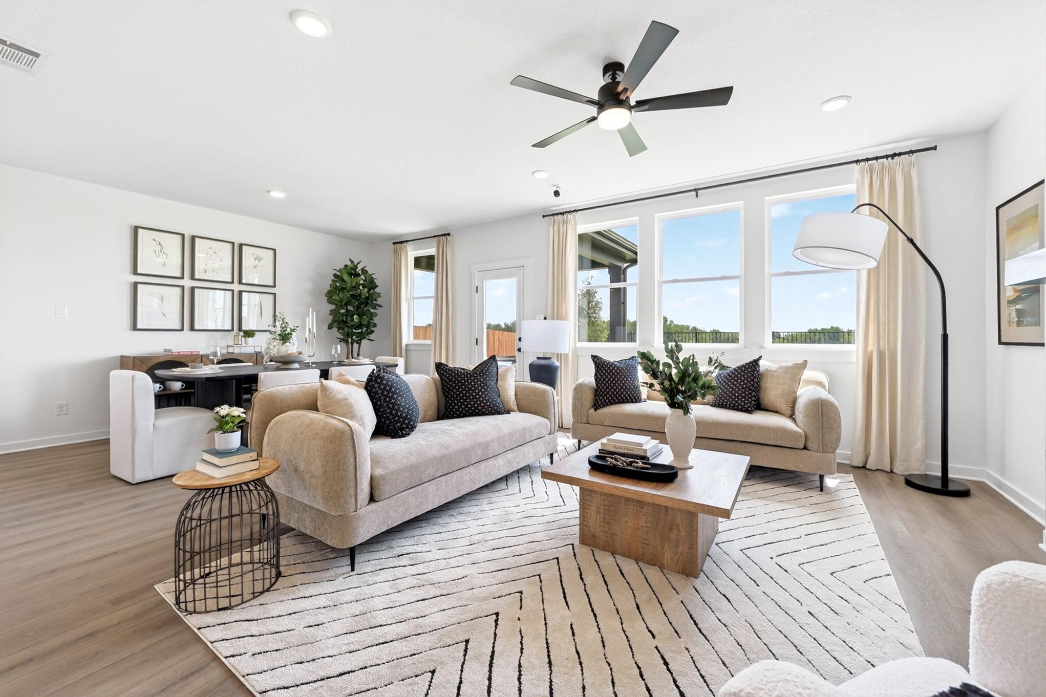 Open-concept living room at Parks at Foster Crossing in Anna, TX by Davidson Homes with modern decor and hardwood floors.
