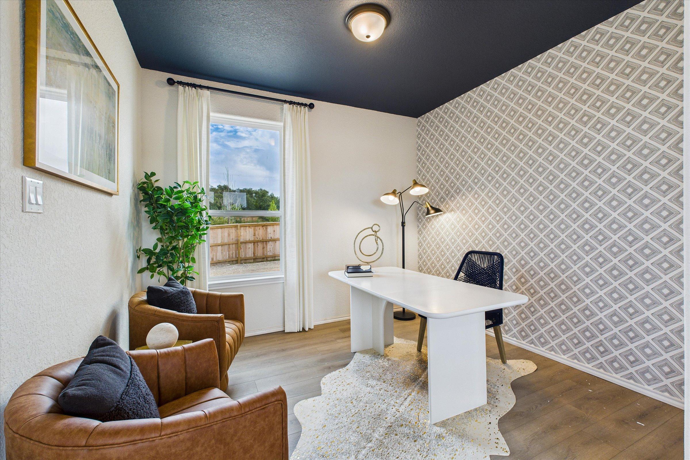 Cozy home office at Meadows at Oak Creek in San Antonio TX with navy ceiling, geometric wallpaper, white desk, leather chairs, and window view
