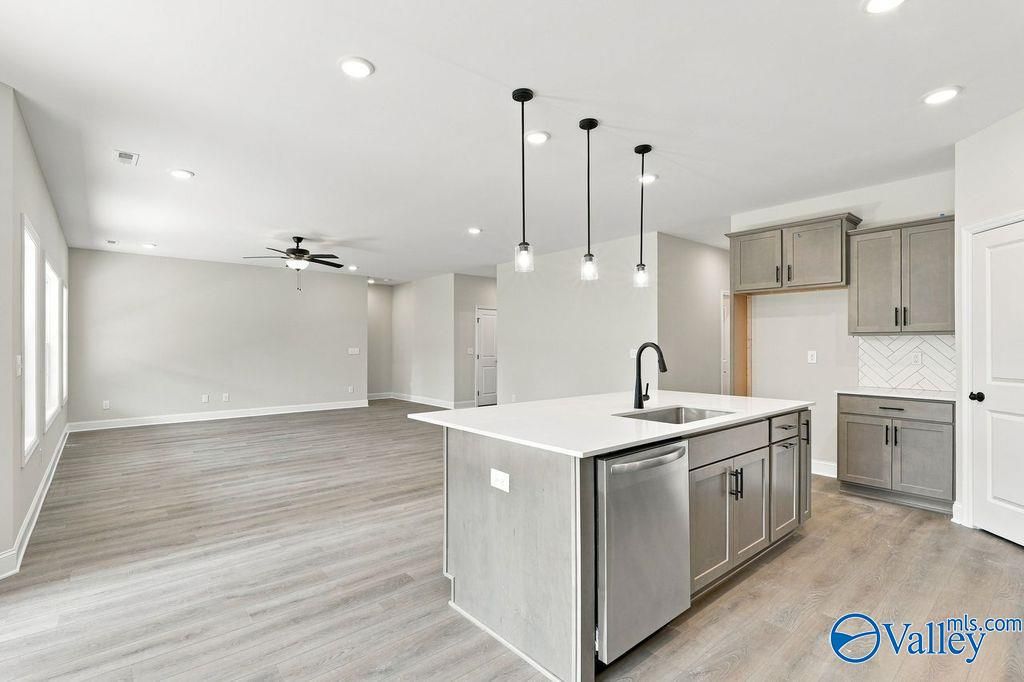 Open-concept kitchen with island, gray cabinetry, and pendant lights in Davidson Homes Rockford floor plan, Hartselle, AL
