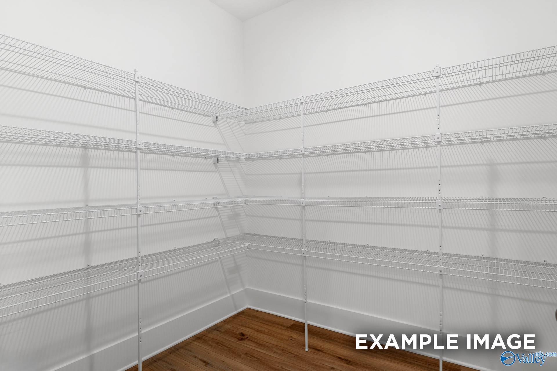 Spacious corner pantry with white wire shelving and hardwood floors in The Finleigh 5-bedroom home, Decatur, Alabama