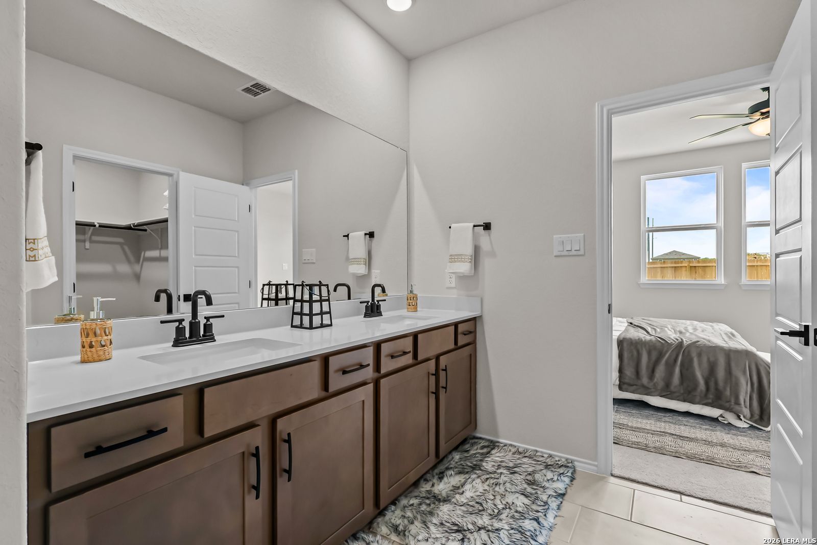 Double vanity bathroom with modern fixtures and walk-in closet in The Douglas C floor plan at Hannah Heights, Seguin, Texas.