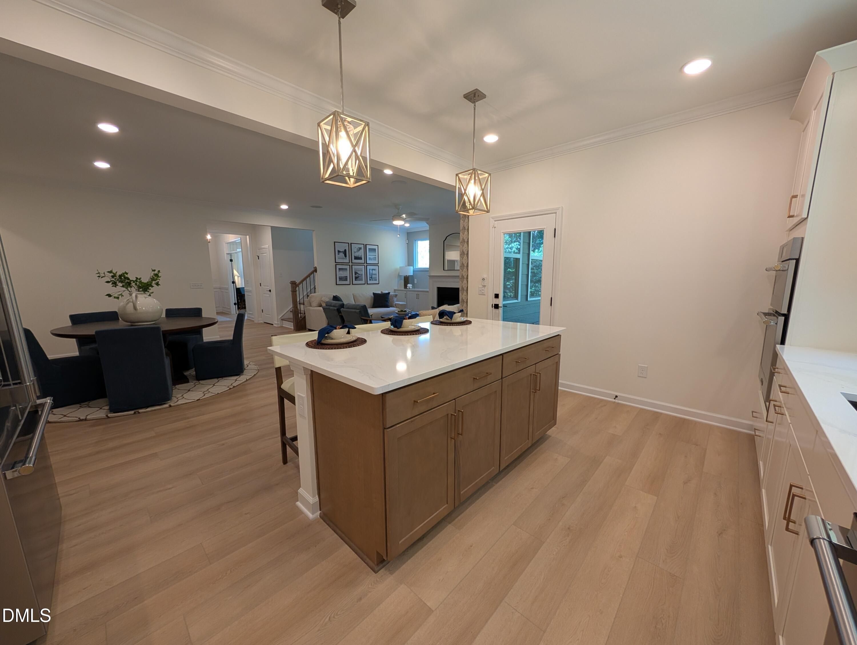 Modern kitchen island with quartz countertops and pendant lighting in The Aspen B floor plan at Wendell Ridge, North Carolina.