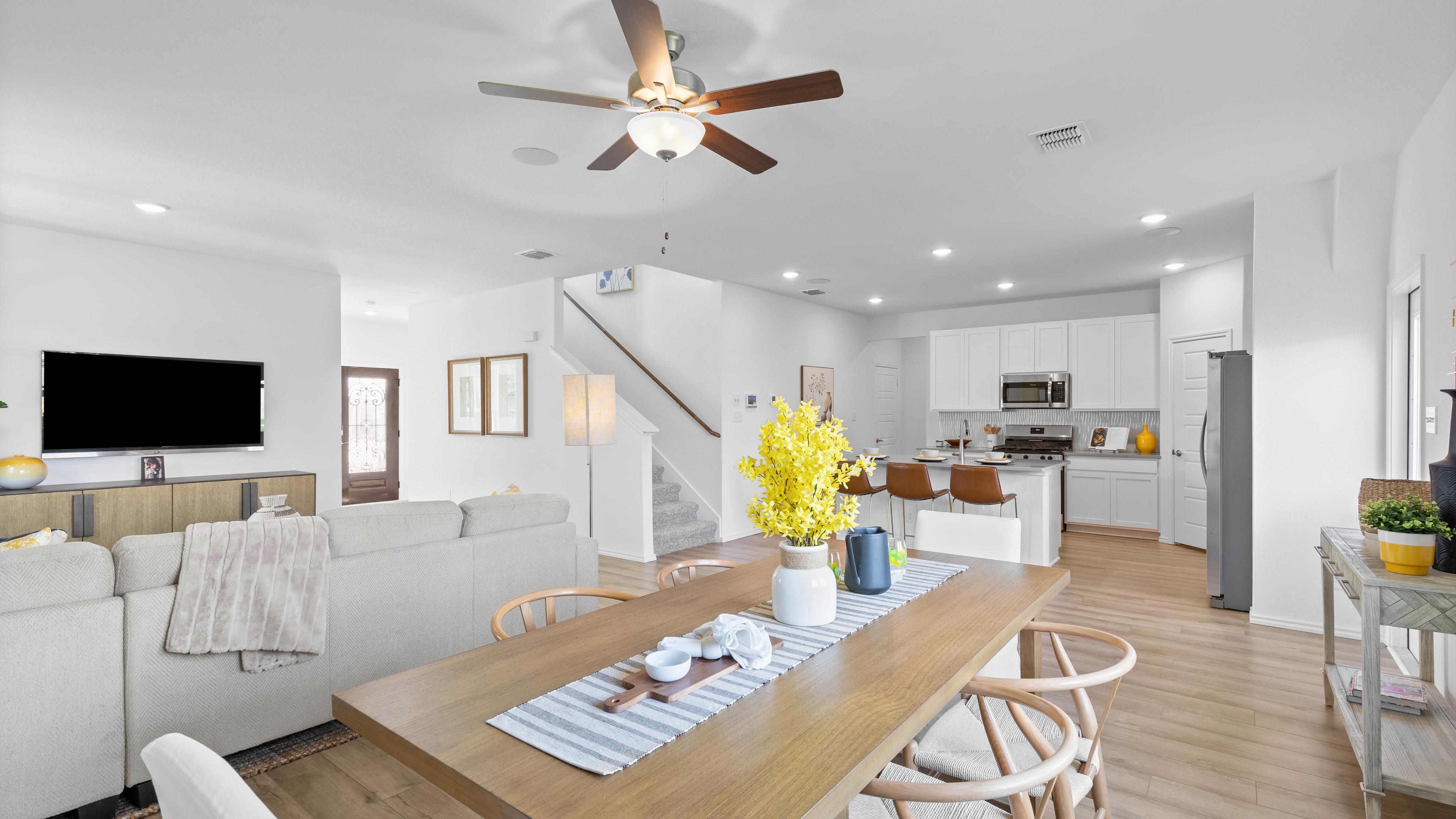 Open-concept living and dining area at Horizon Pointe in Converse TX with hardwood floors, white kitchen cabinets, and ceiling fan