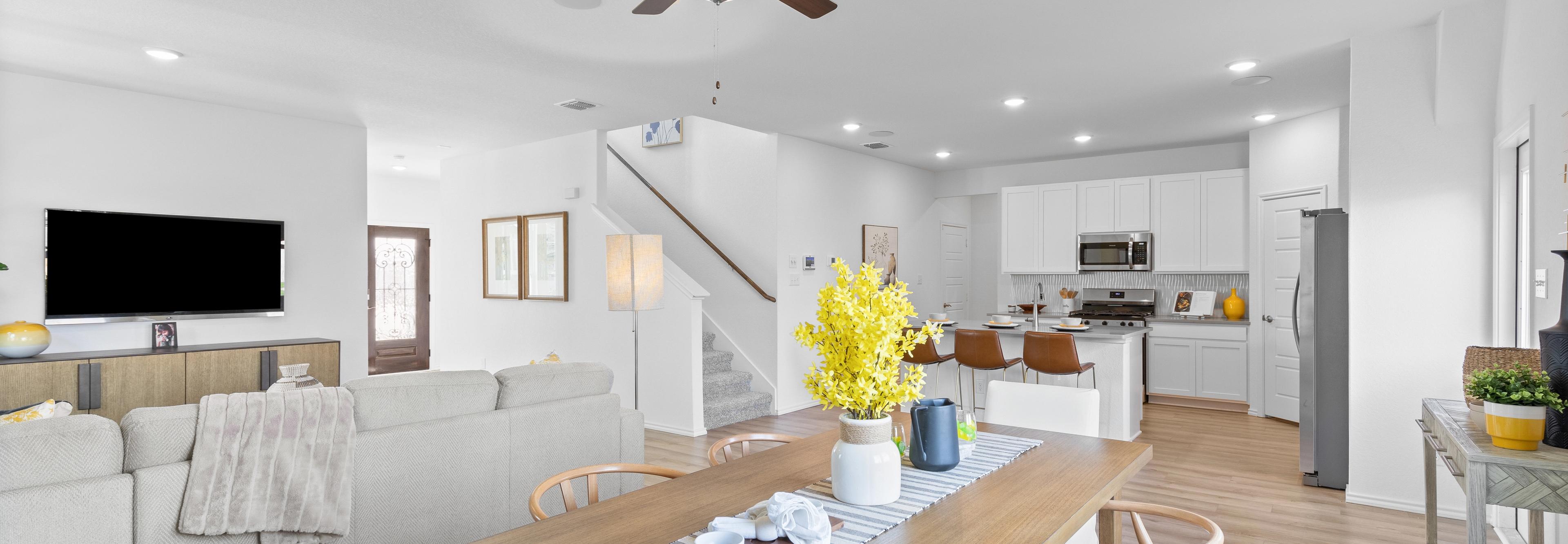Open-concept living and dining area at Horizon Pointe in Converse TX with hardwood floors, white kitchen cabinets, and ceiling fan