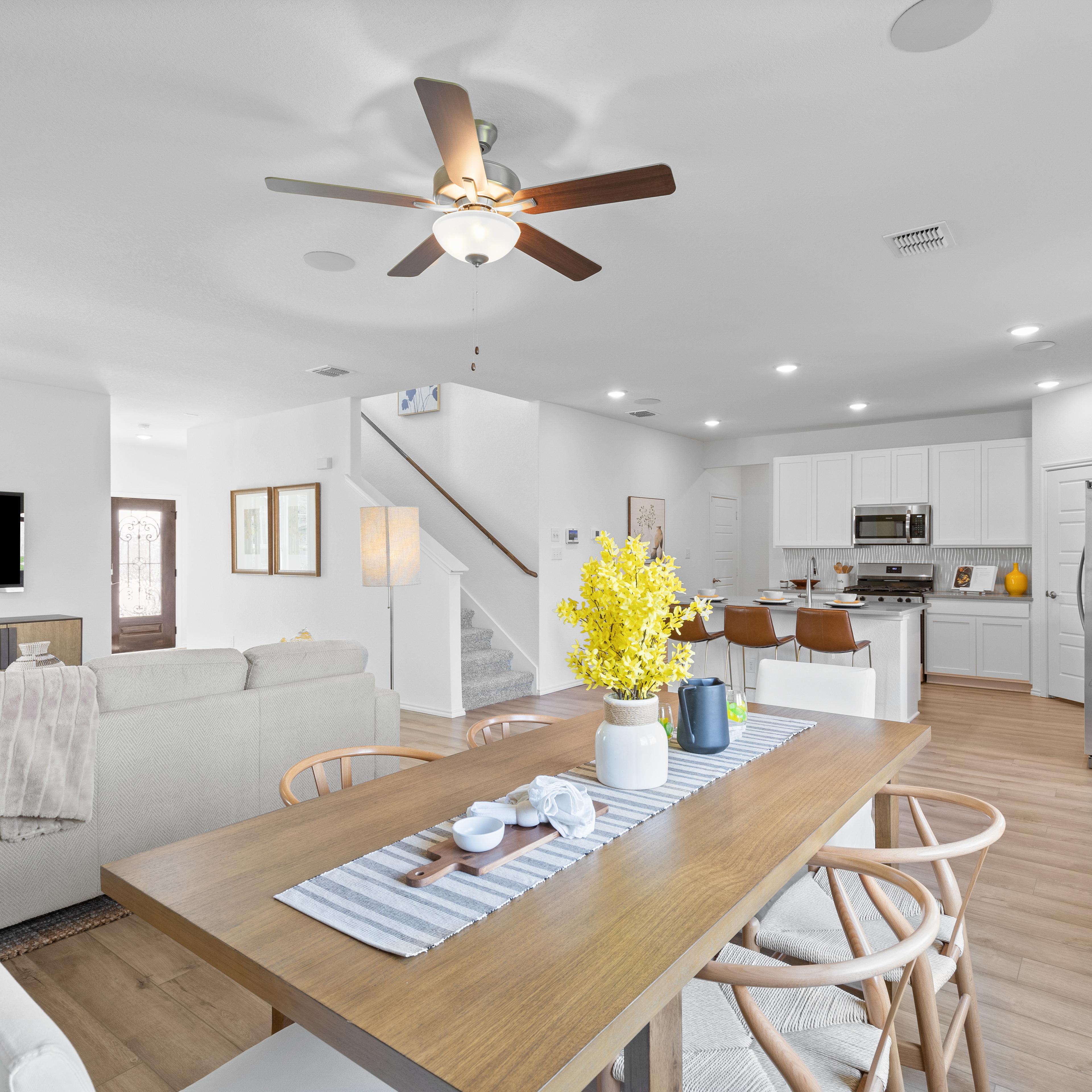 Open-concept living and dining area at Horizon Pointe in Converse TX with hardwood floors, white kitchen cabinets, and ceiling fan