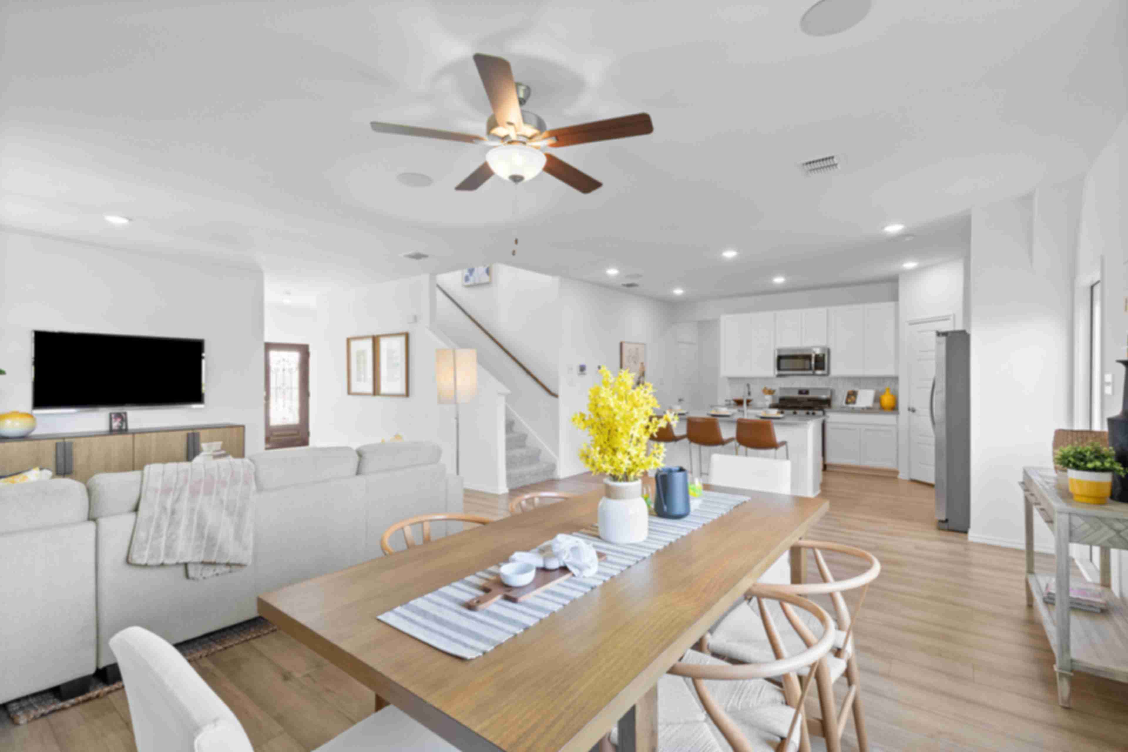 Open-concept living and dining area at Horizon Pointe in Converse TX with hardwood floors, white kitchen cabinets, and ceiling fan