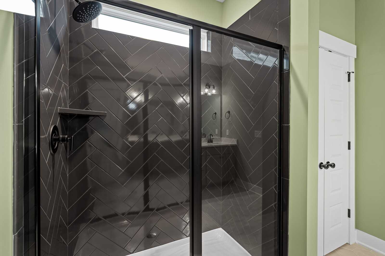 Luxurious master bathroom with black subway tile walk-in shower and glass enclosure in Davidson Homes The Ridgeport, Gallatin, TN
