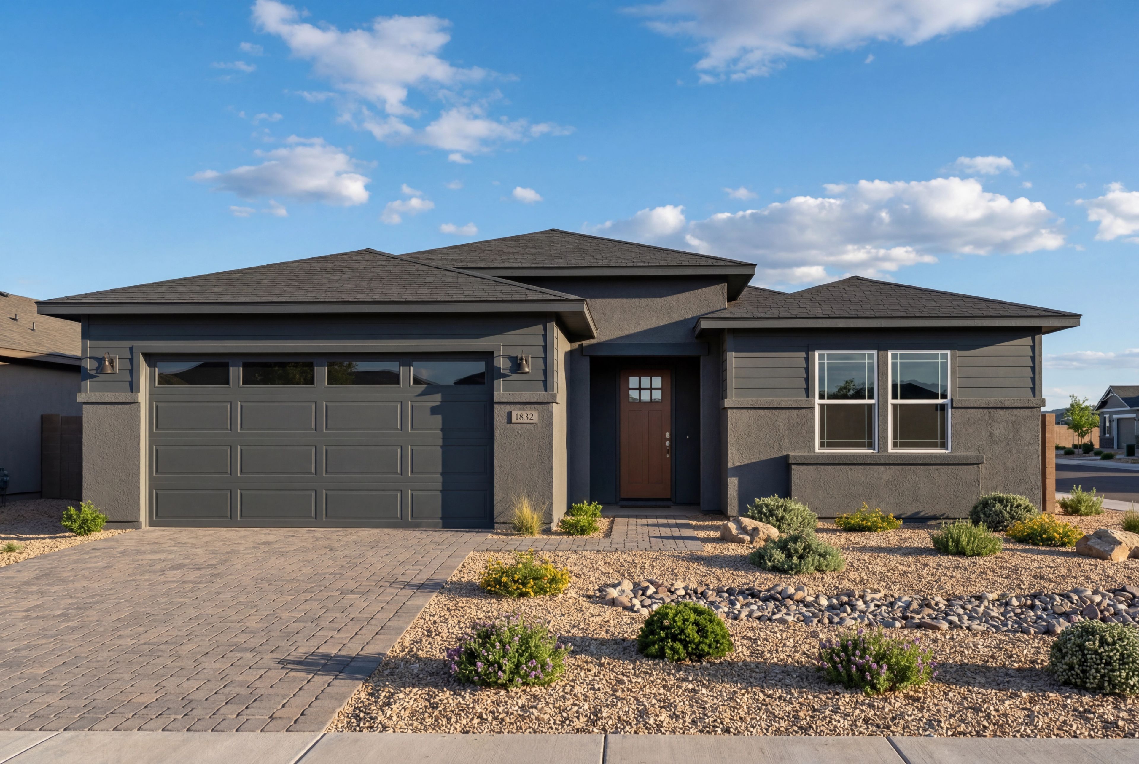 Modern dark grey exterior of The Durango II home design in Prescott, Arizona featuring a 3-car garage and desert landscape.