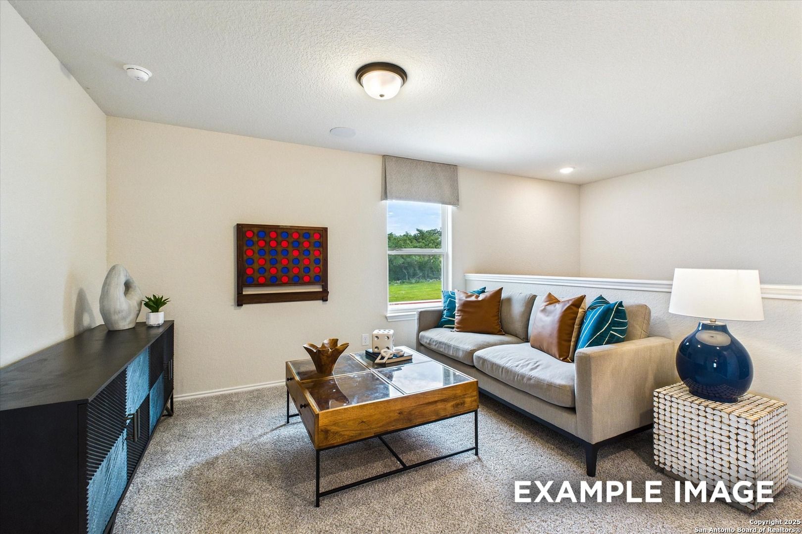 Cozy living room with beige sofa, glass coffee table, large window overlooking greenery in Davidson Homes The Florence C, San Antonio