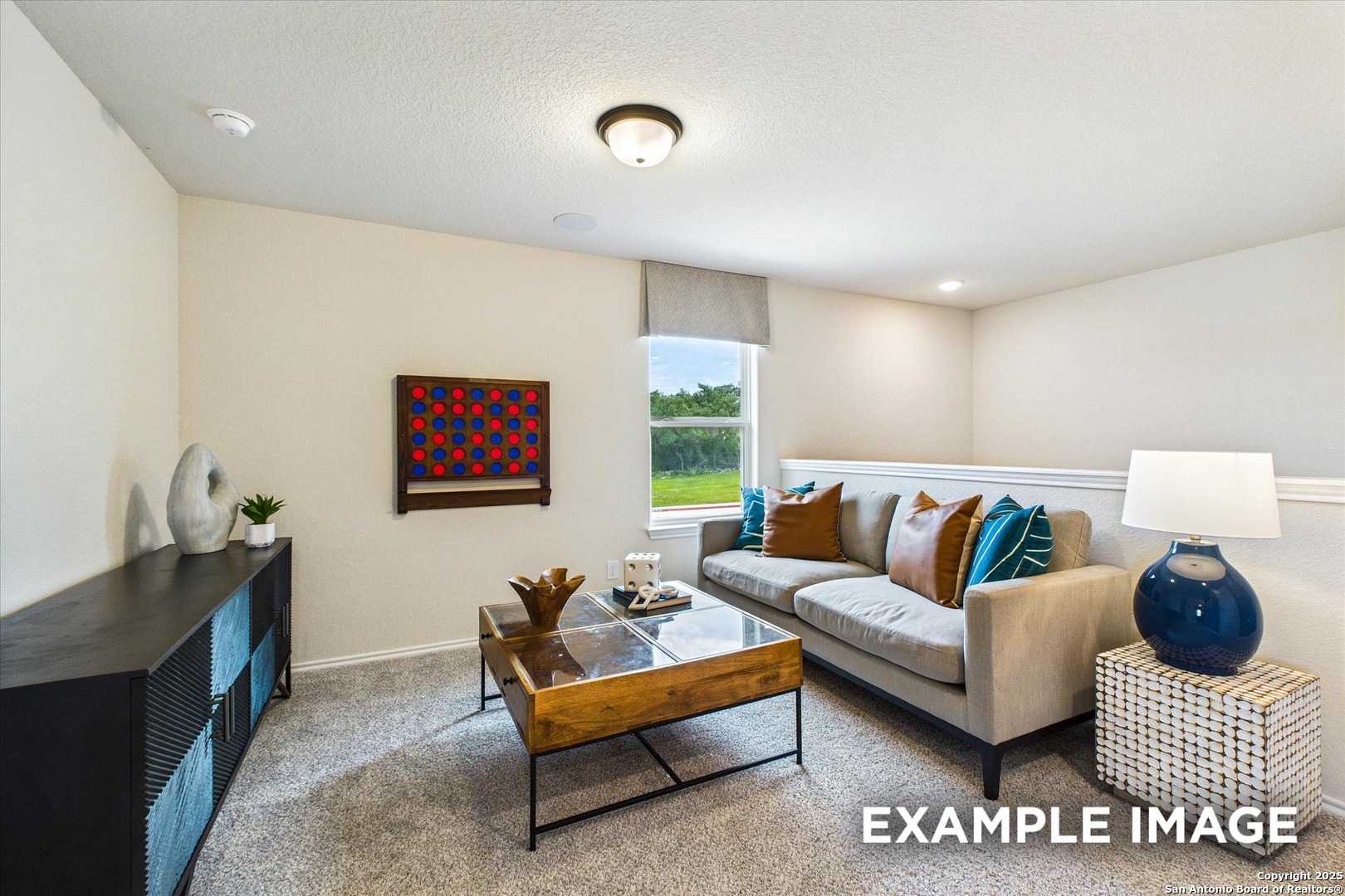 Cozy living room with beige sofa, glass coffee table, large window overlooking greenery in Davidson Homes The Florence C, San Antonio