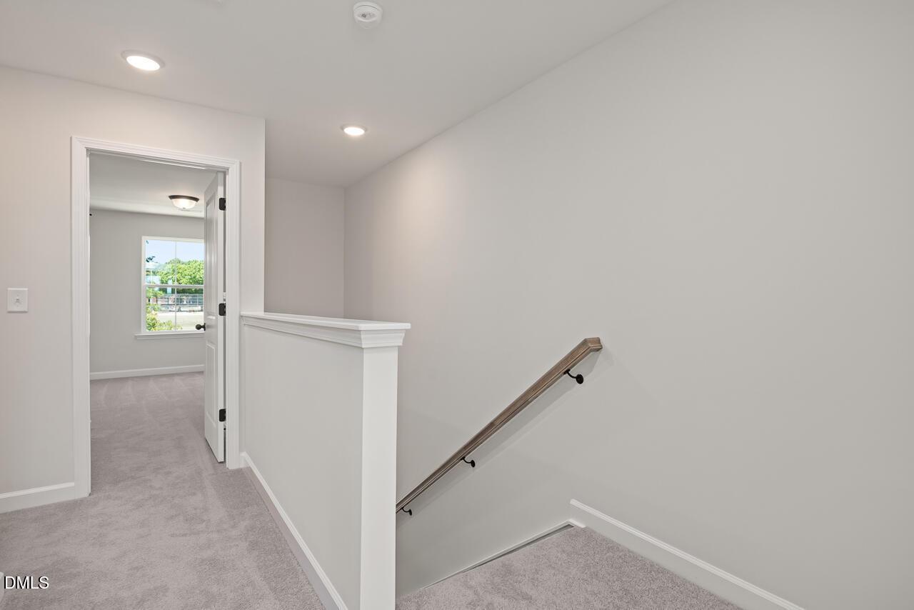 Bright second-floor landing with plush carpet and staircase in The Mitchell floor plan at Camden Park, Knightdale, NC.