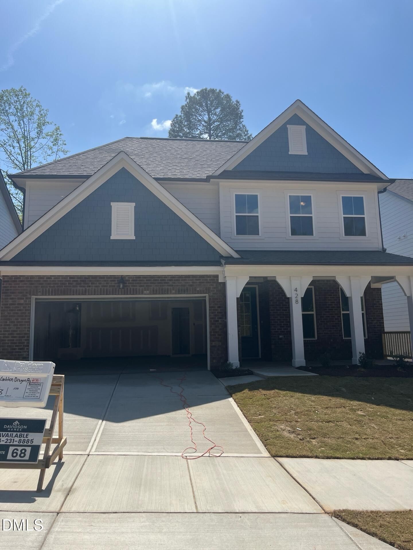 Modern two-story Ashport L home with blue siding, brick garage, columned porch, and Davidson Homes sign in Wake Forest, NC