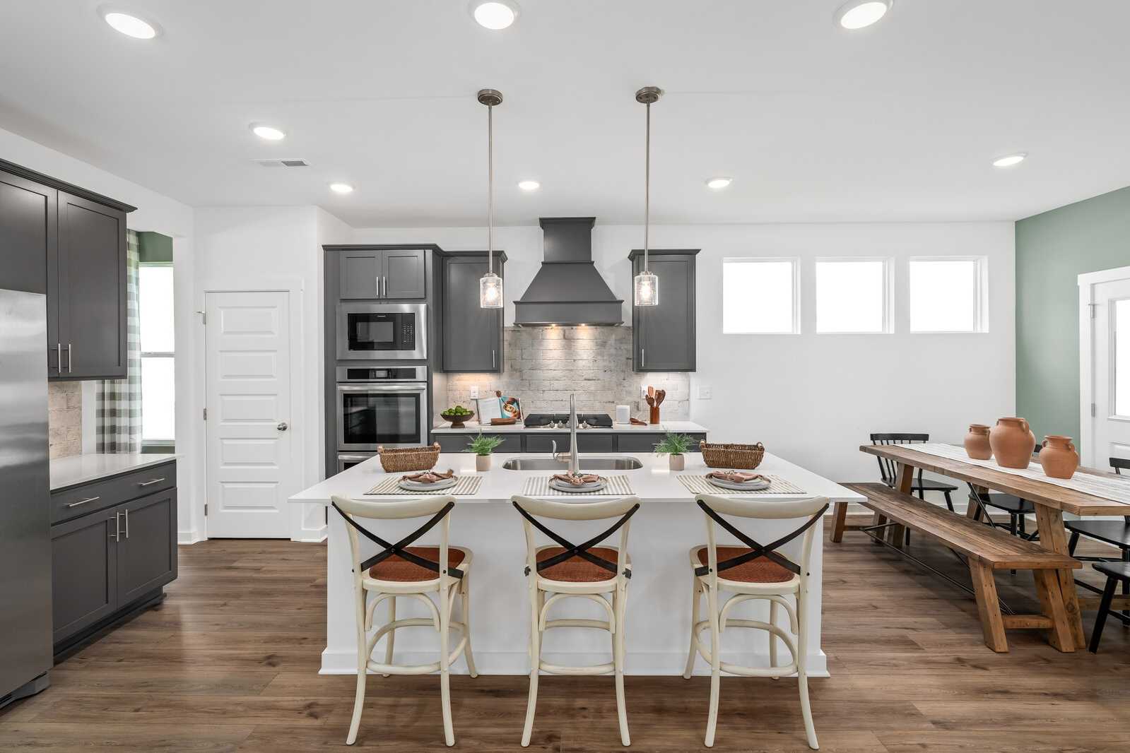 Spacious modern kitchen at Calista Farms in White House Tennessee with white island, dark cabinets and hardwood floors