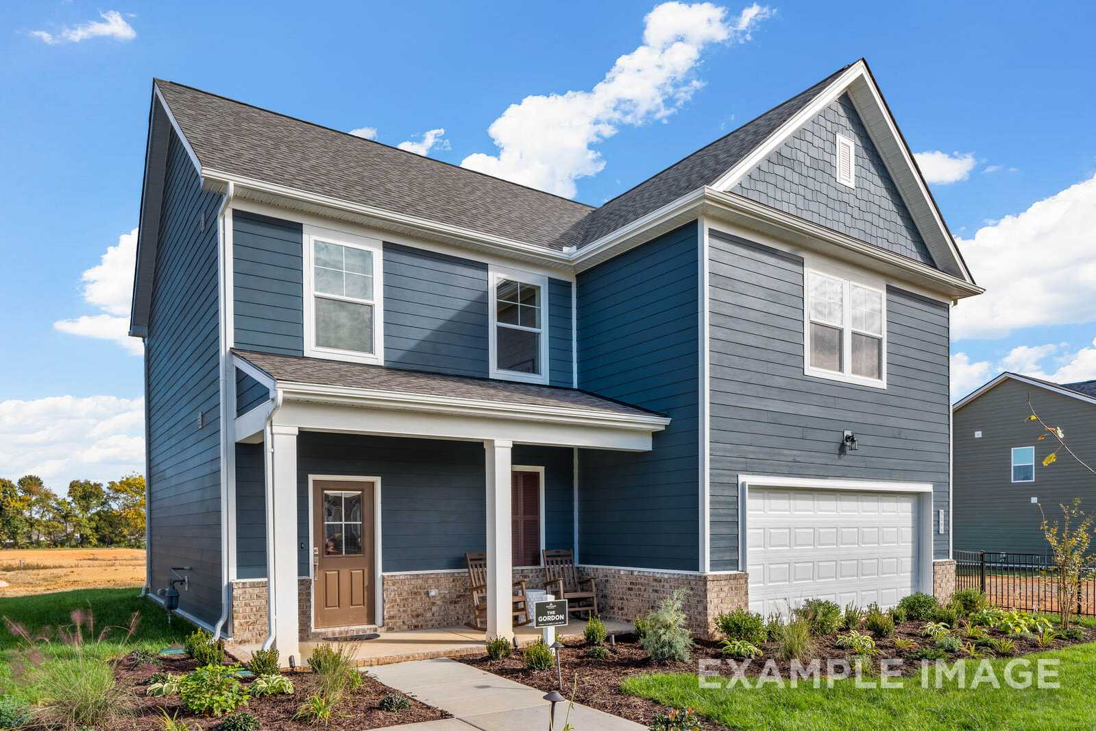 Two-story Gordon B home exterior with navy blue siding, gabled roof, covered porch, two-car garage, and landscaped yard by Davidson Homes