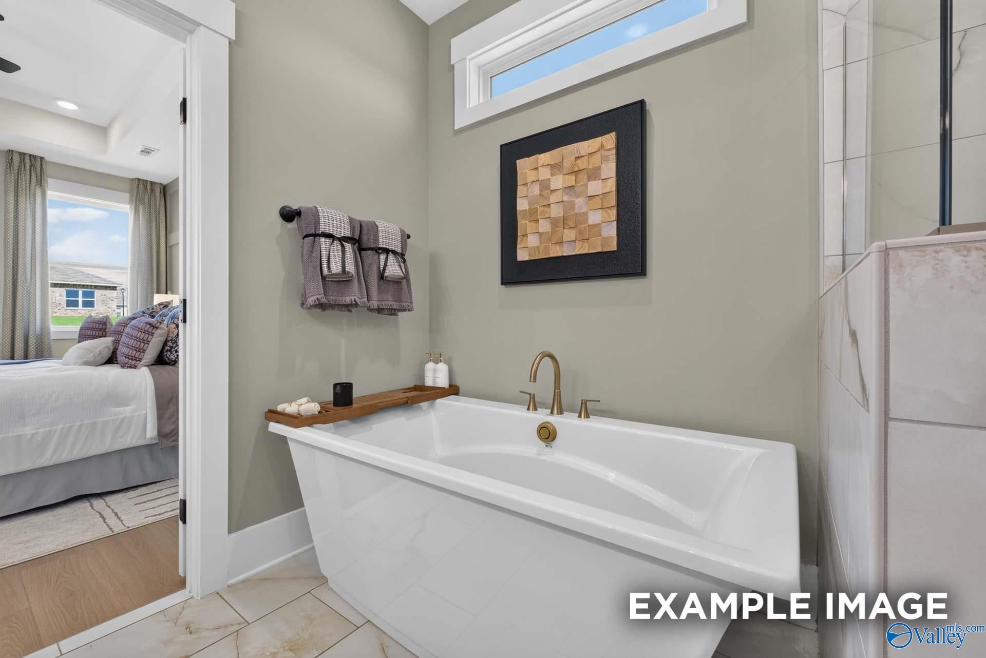 Freestanding soaking tub with brushed gold faucet in master bath of Davidson Homes Ashport K plan, Forest Glen, Hazel Green, Alabama