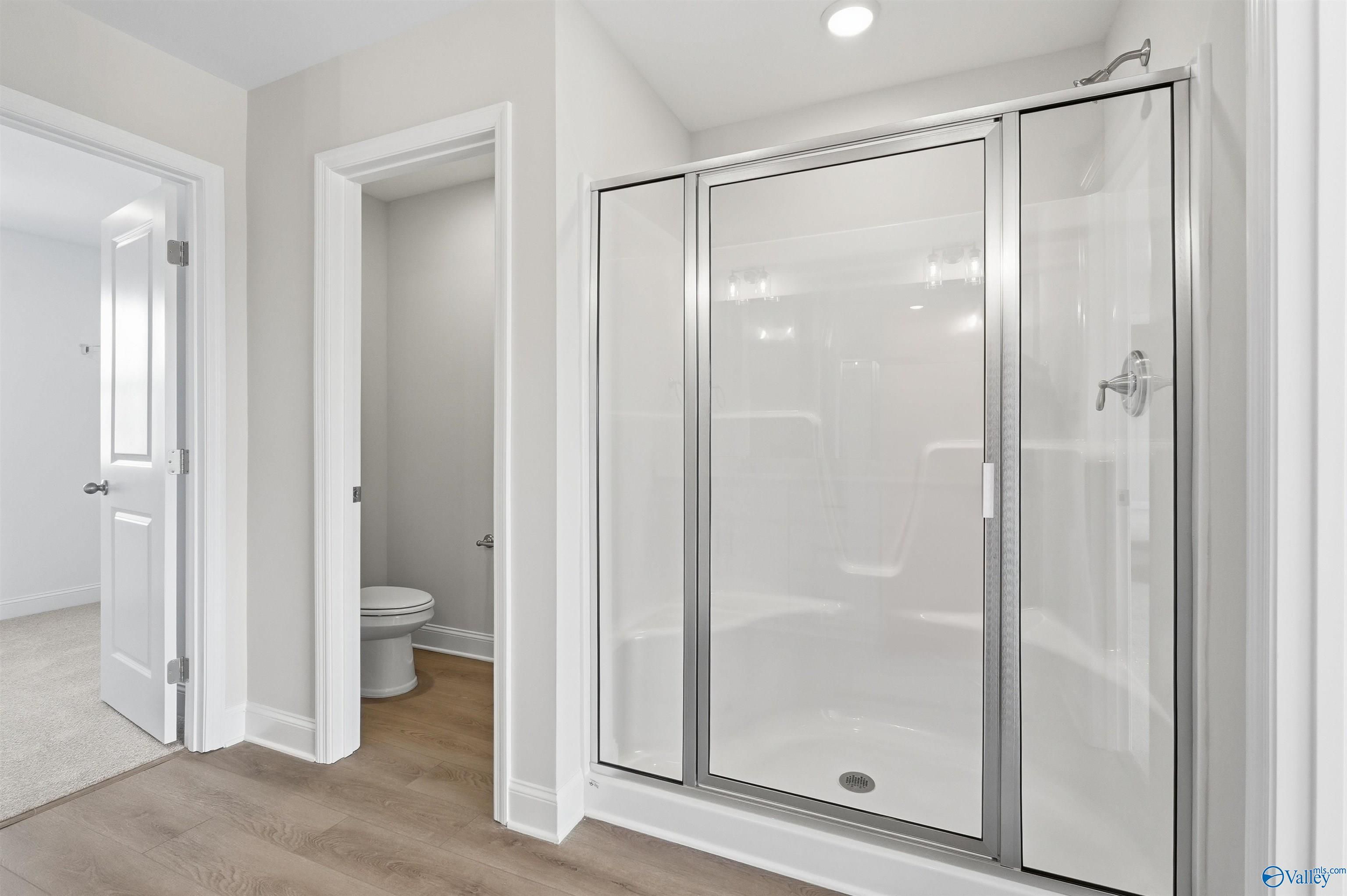 Walk-in shower with glass door and private water closet in The Shelby D floor plan by Davidson Homes in Madison, Alabama.