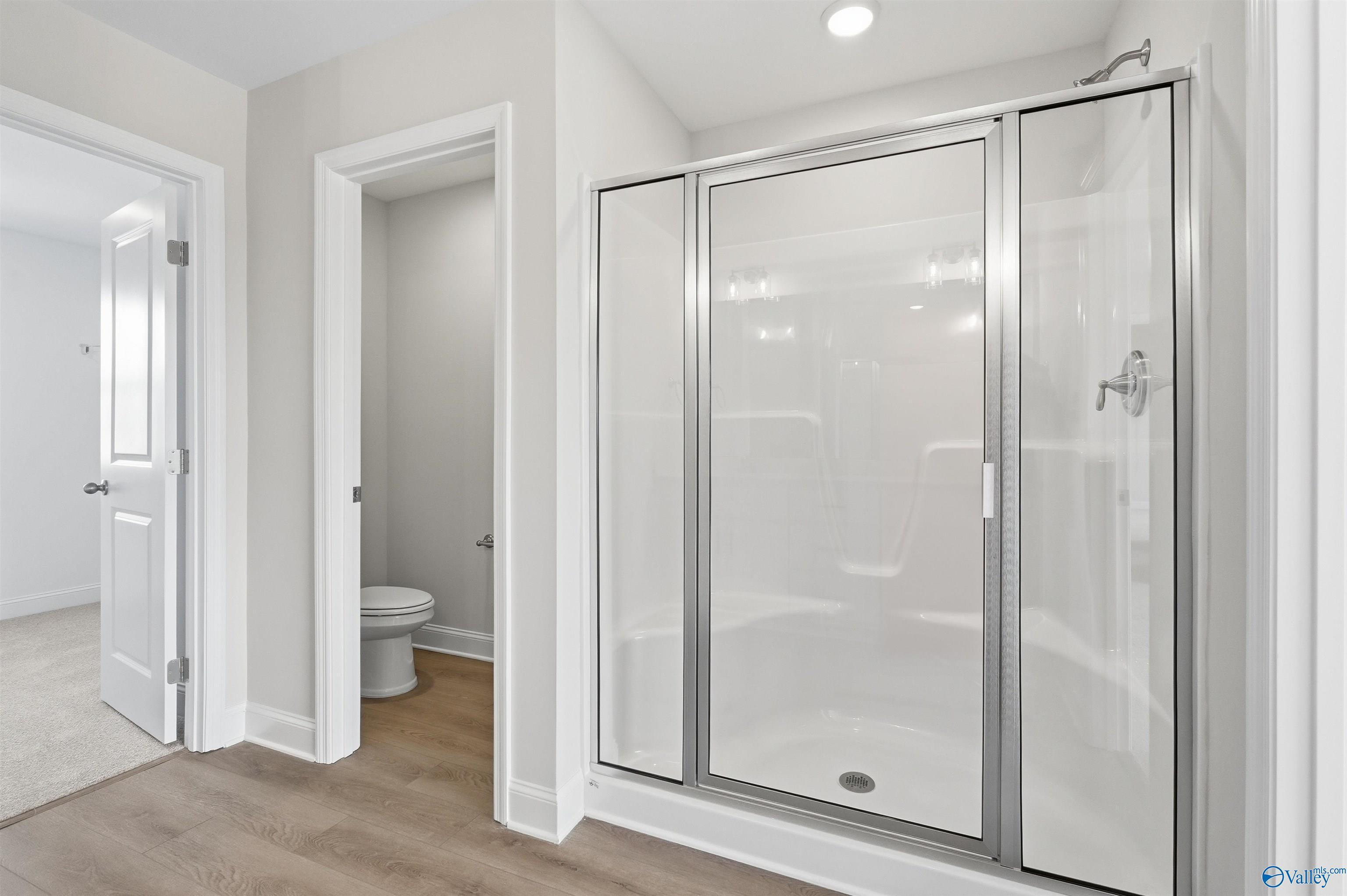 Walk-in shower with glass door and private water closet in The Shelby D floor plan by Davidson Homes in Madison, Alabama.