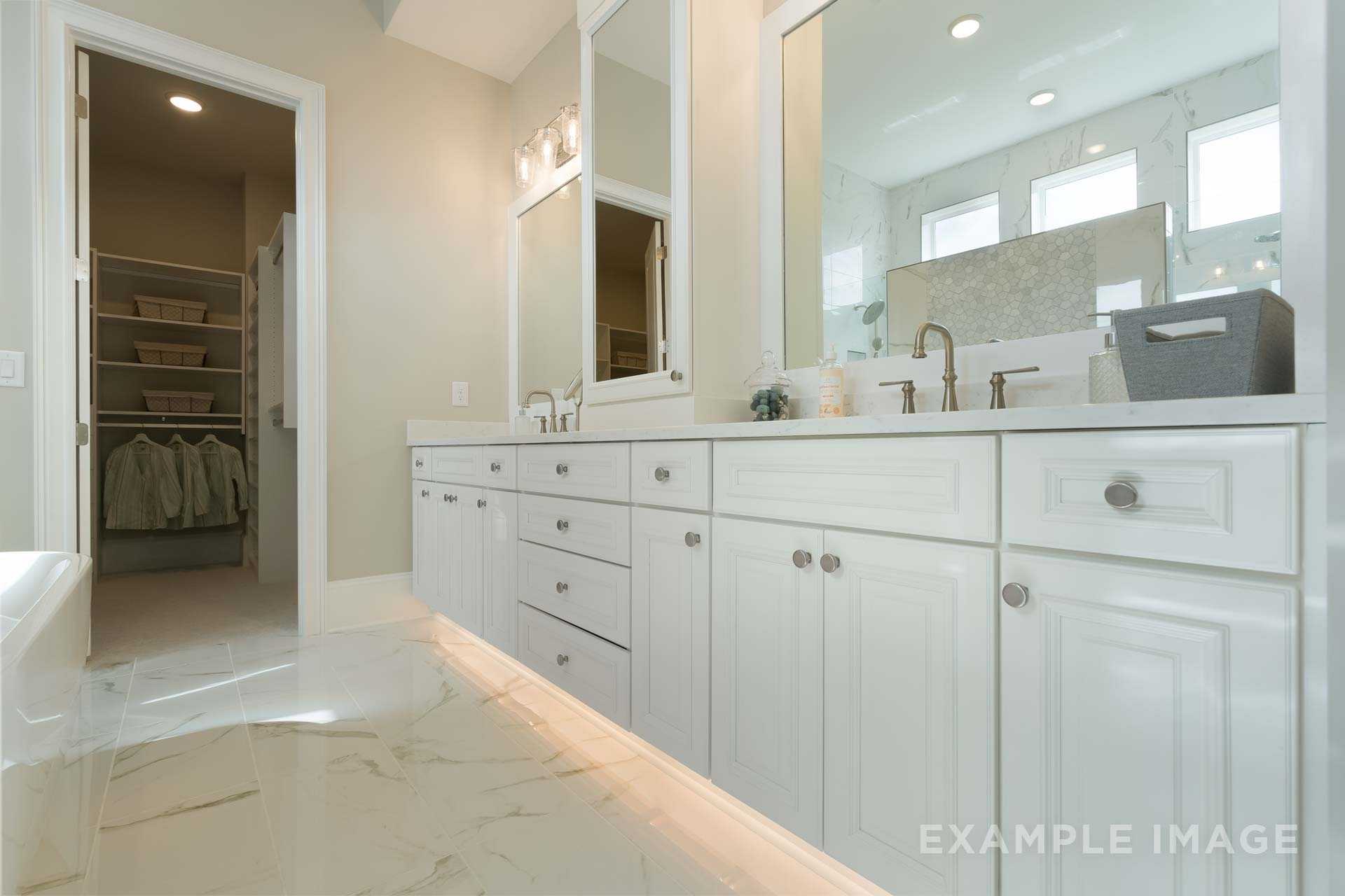 Spacious master bathroom in The Seaside by Davidson Homes, with double vanity, freestanding tub, and adjacent walk-in closet